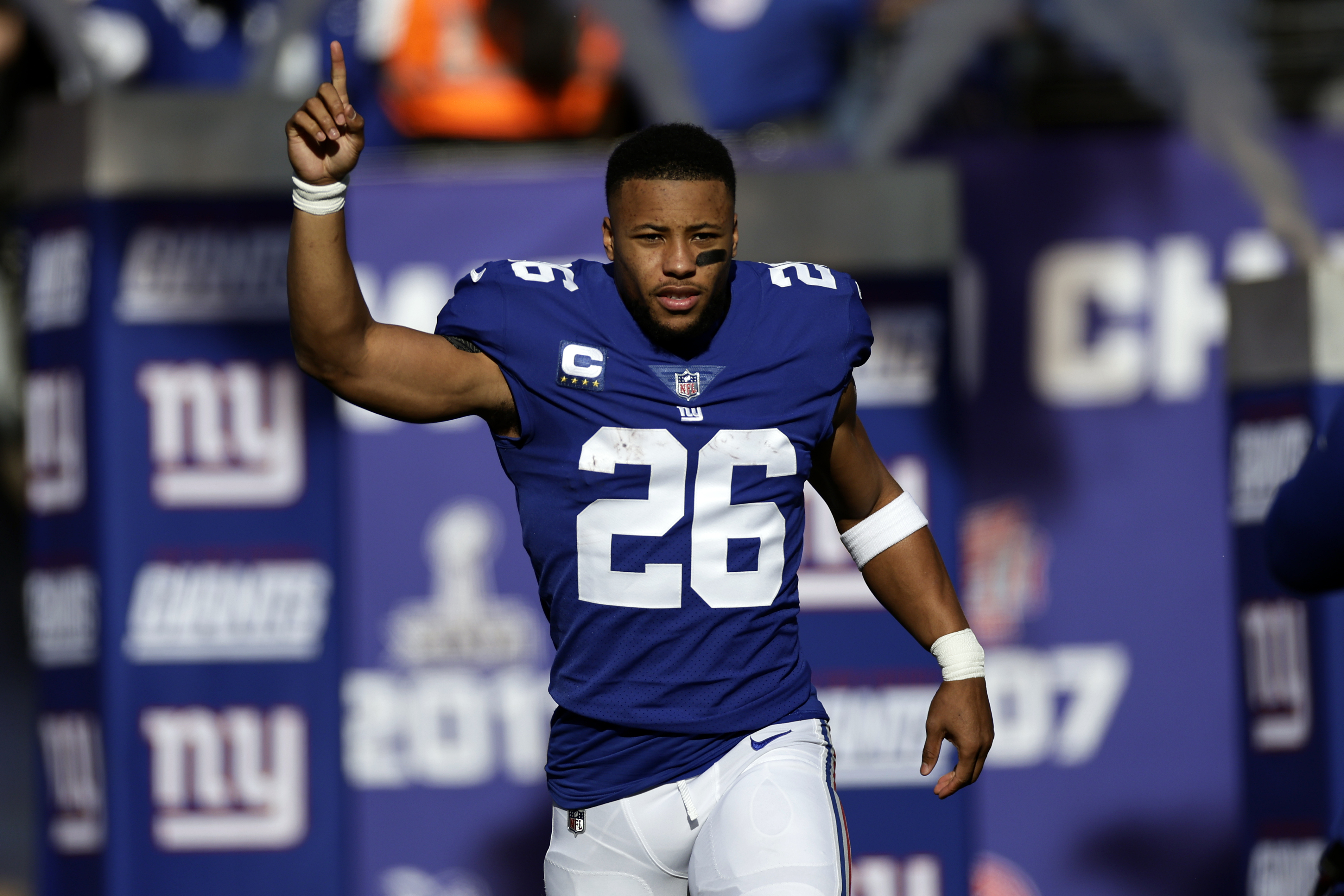 New York Giants players surround running back Saquon Barkley