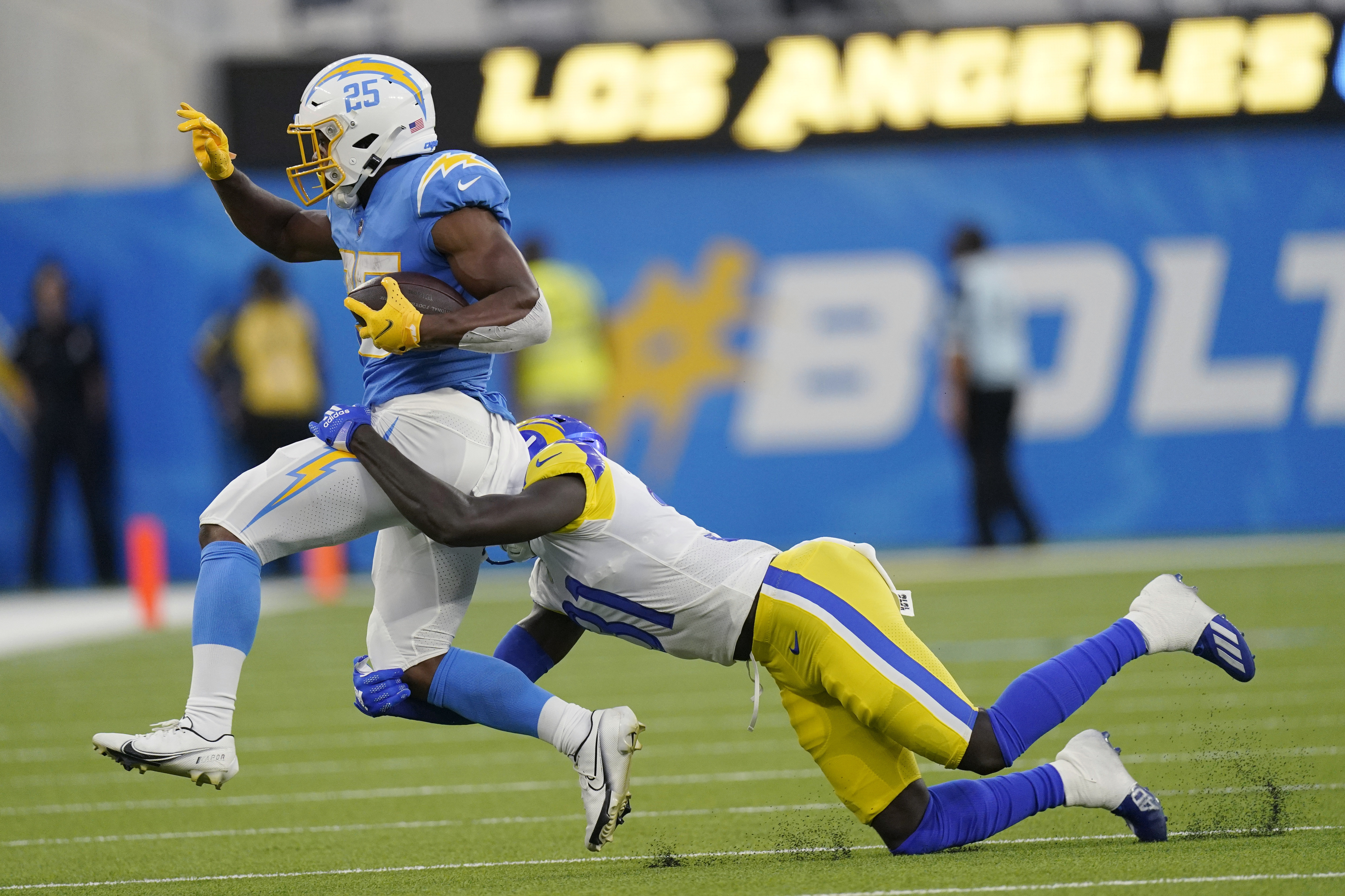 Los Angeles Rams quarterback Bryce Perkins (16), top, leaps over Los Angeles  Chargers defensive back Kemon