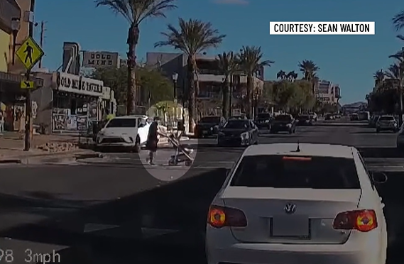 Dashcam view of a person pushing a baby stroller waiting at a Water Street crosswalk in Henderson as cars pass through, video courtesy Sean Walton (image: FOX5 Vegas)