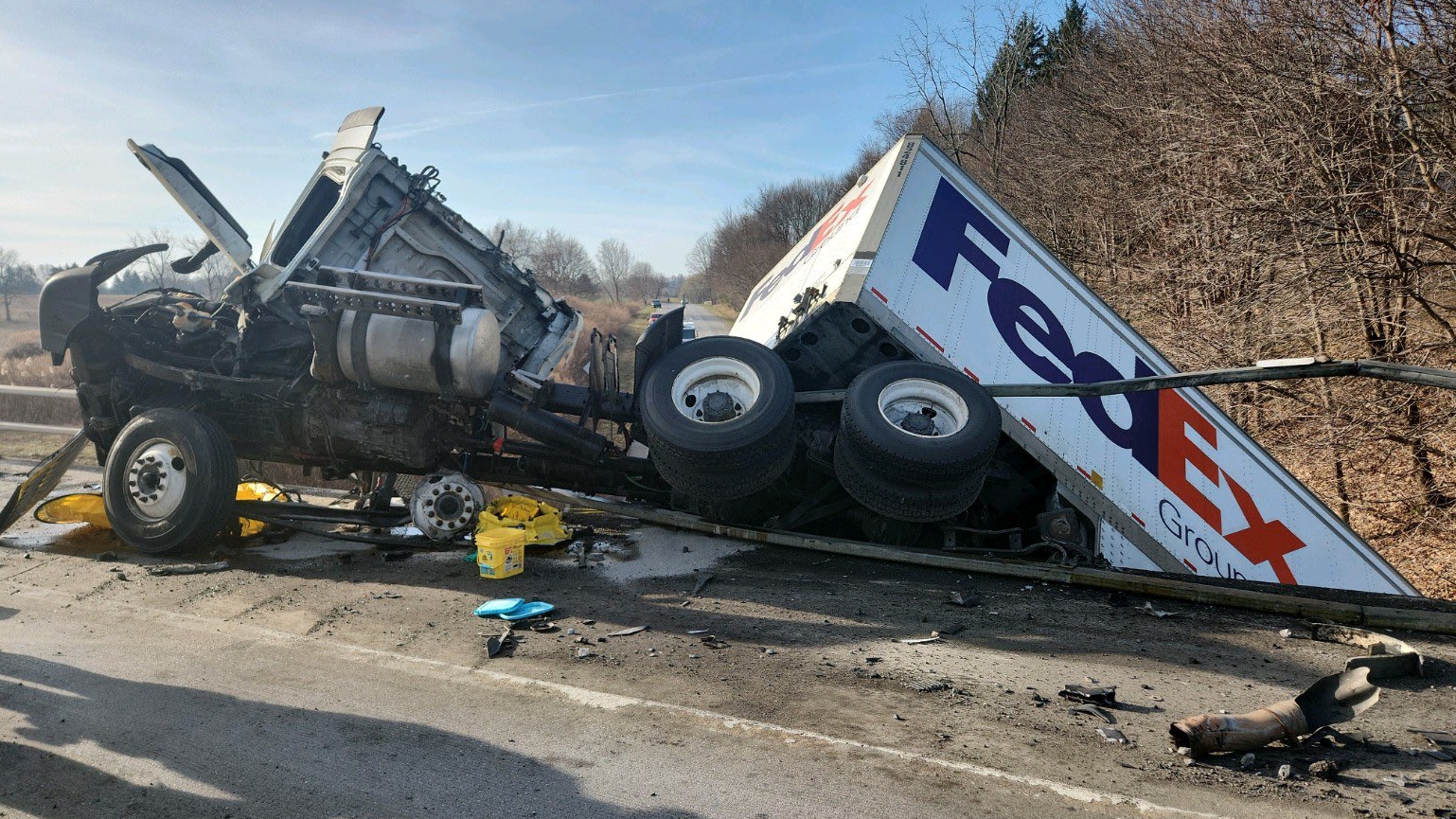 Officials: Overturned FedEx tractor-trailer breaks through 