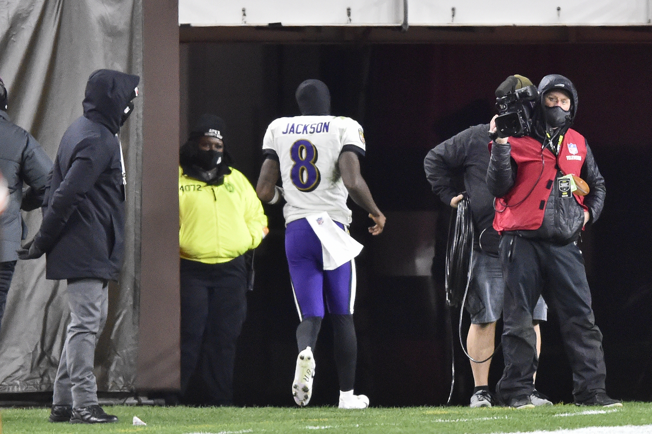 Lamar Jackson of the Baltimore Ravens wipes his face during a time