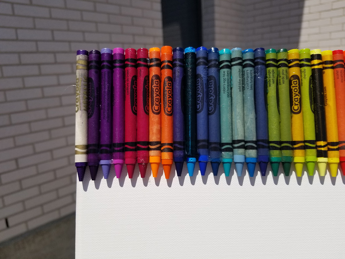 only the tips of colored crayons can be seen at the bottom of the