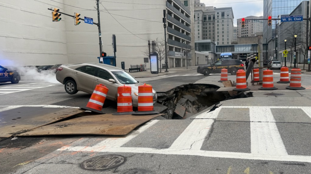 Car nearly falls into massive sinkhole