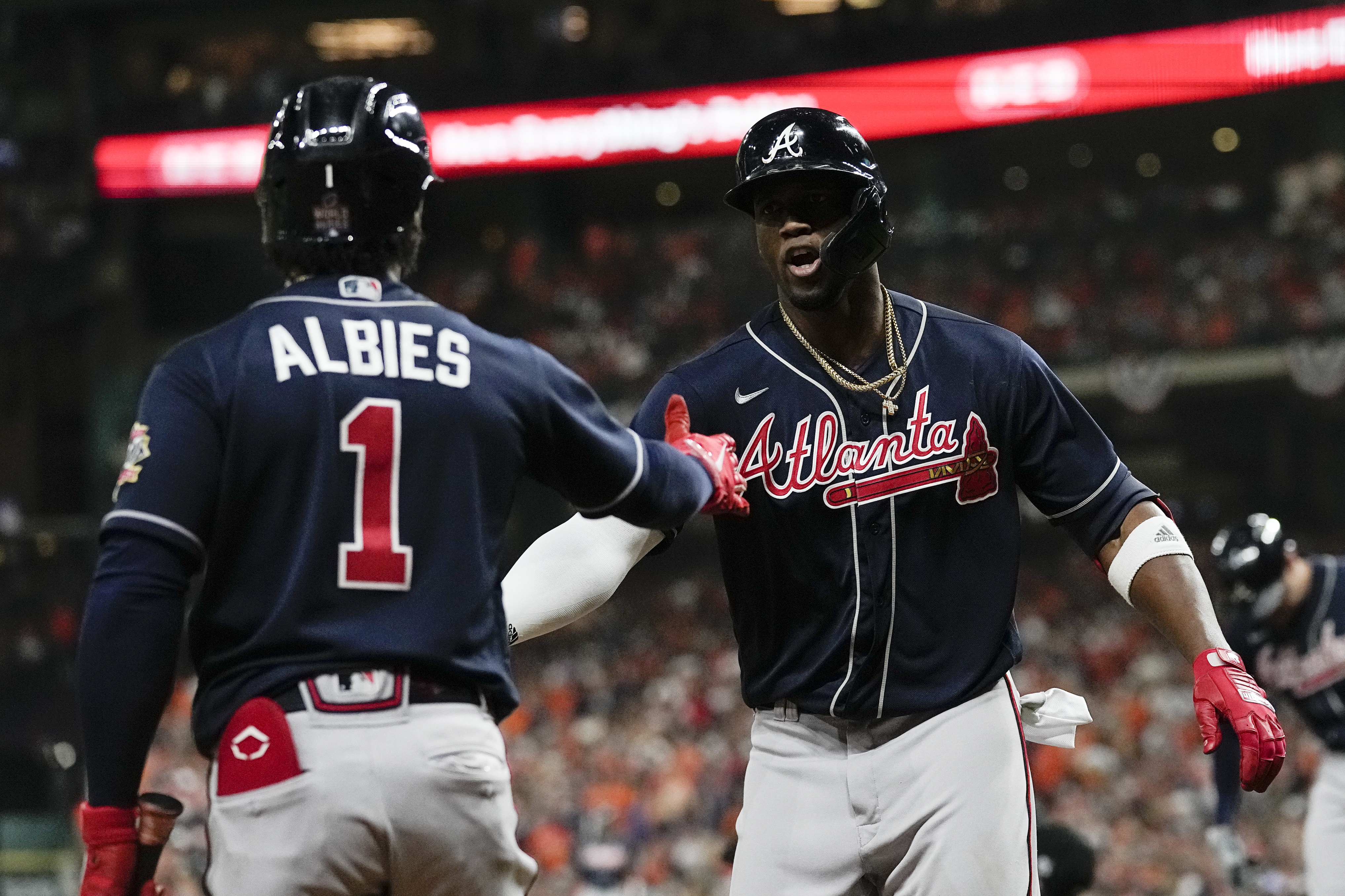 Atlanta Braves' Adam Duvall, right, celebrates his two-run home run in the  dugout during the third inning of Game 1 in baseball's World Series between  the Houston Astros and the Atlanta Braves