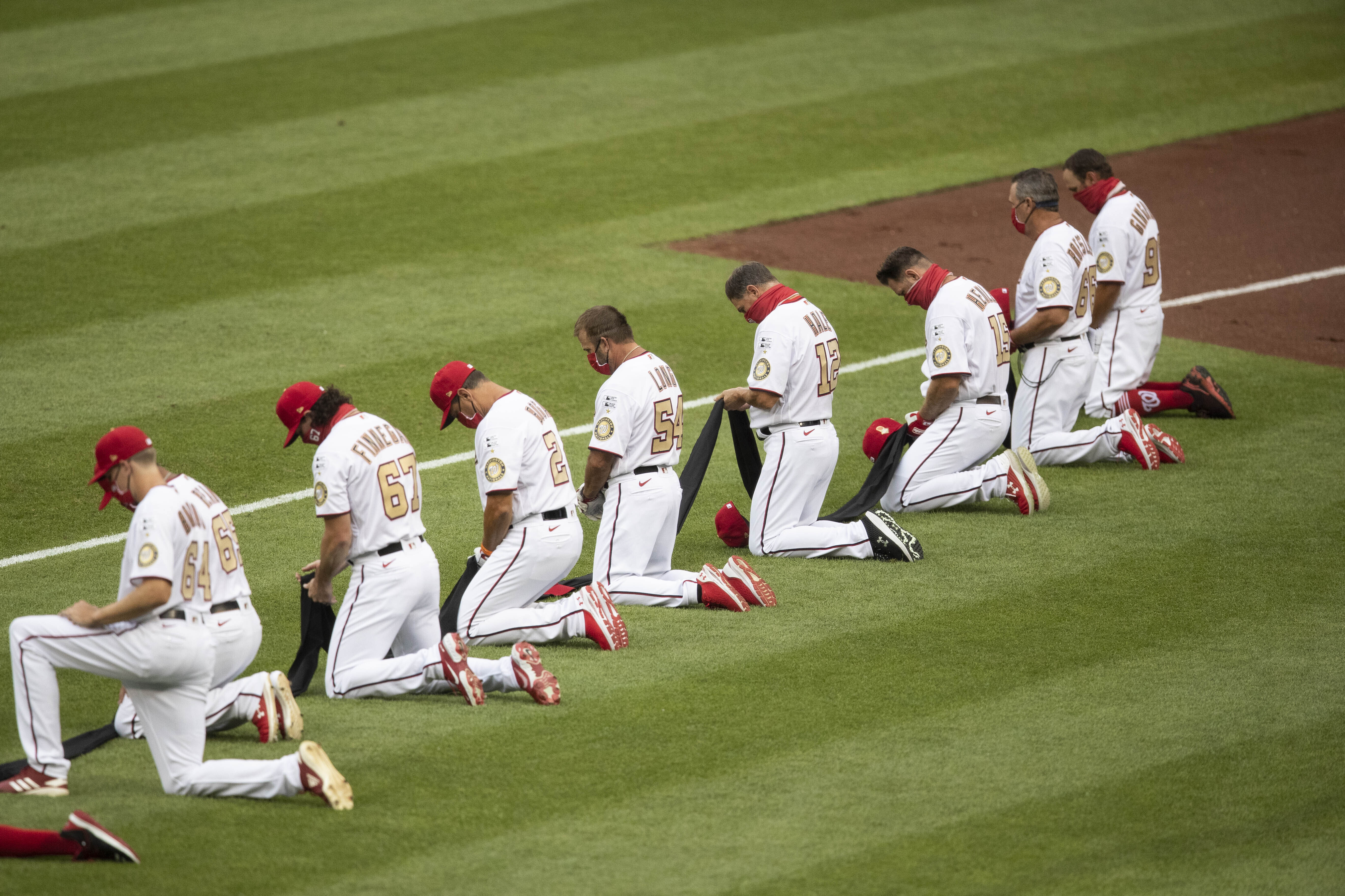 members of the St. Louis Cardinals stand for the National Anthem