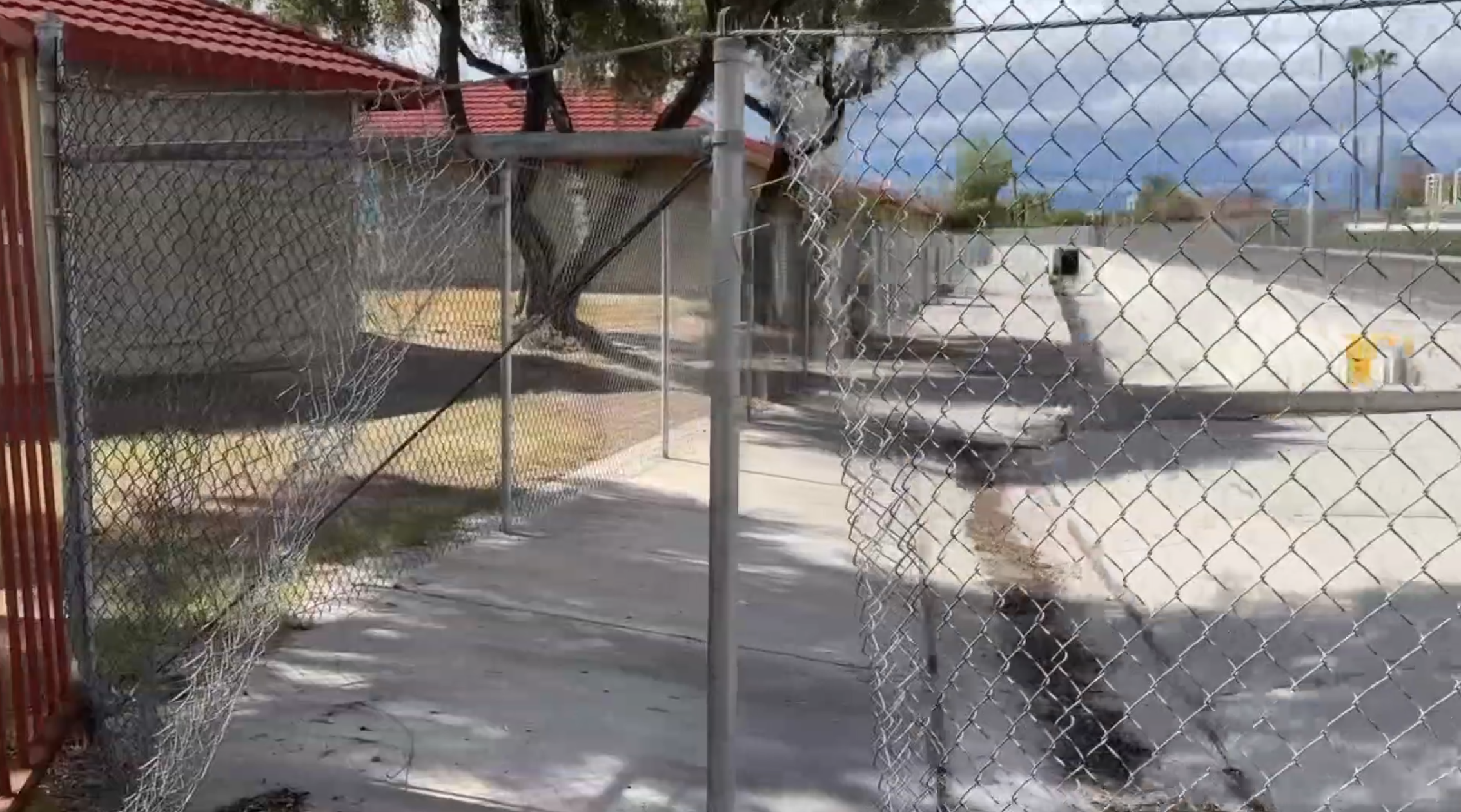 Cut and damaged chain link fencing next to a concrete drainage channel near Topaz Street and Tompkins Avenue in the east Las Vegas valley