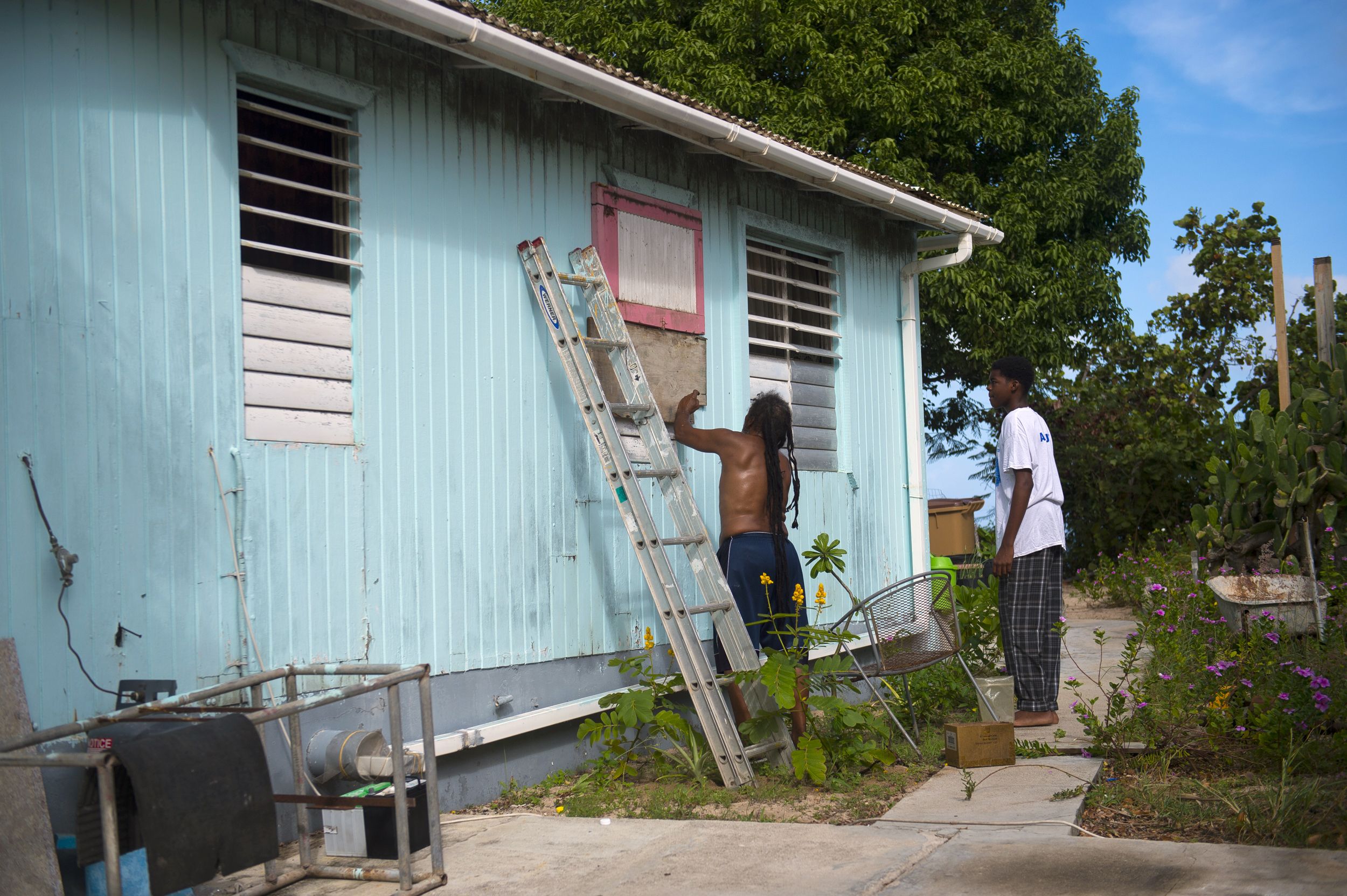 Personas colocan tablas para proteger las ventanas de una vivienda en Marigot, en la isla francesa San Martín.