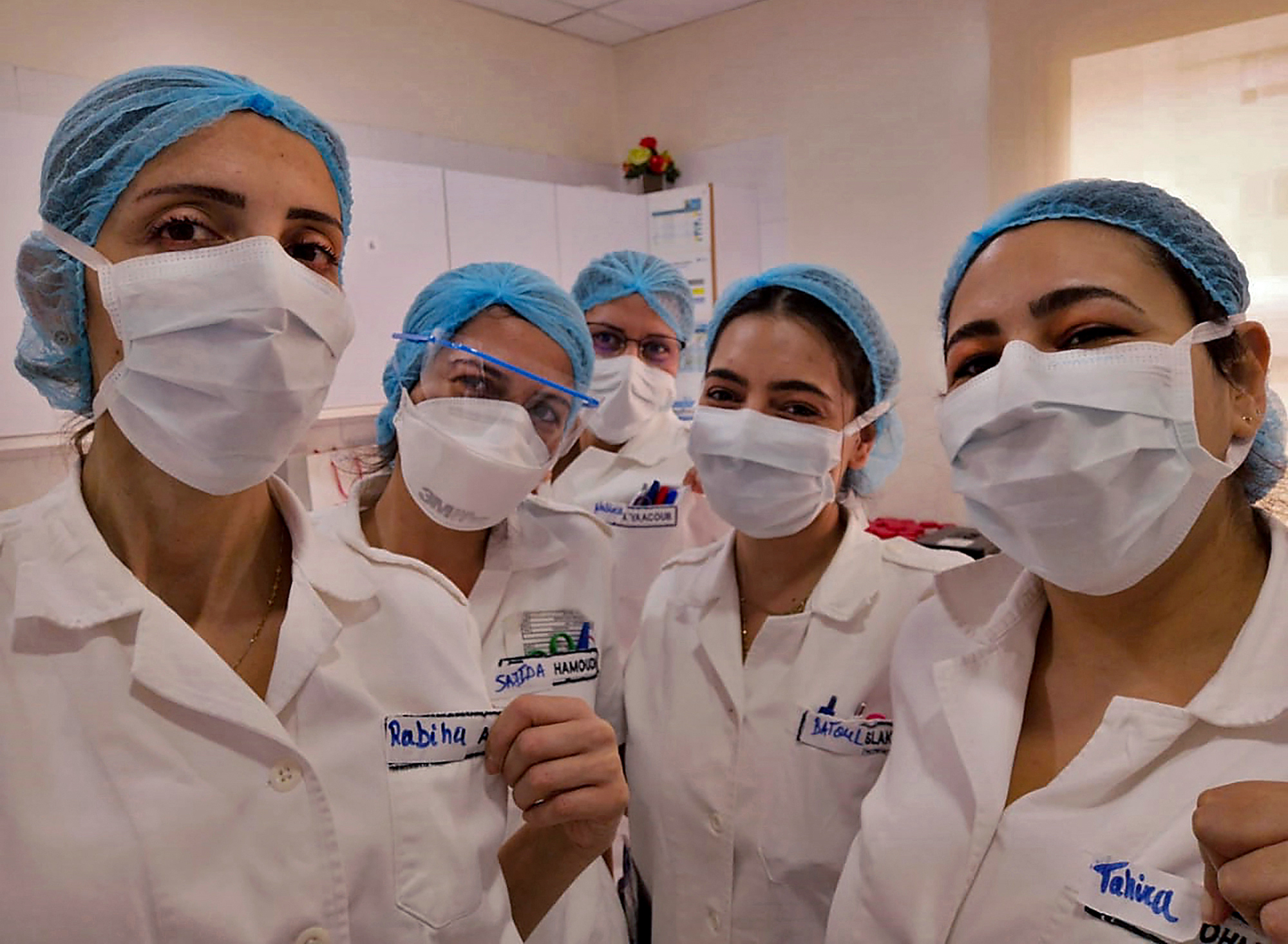 A picture taken by a nurse on April 8, 2020 at the Hotel Dieu de France University Hospital, shows colleagues wearing protective face masks in the coronavirus COVID-19 section of the hospital, in the neighbourhood of Ashrafieh of the Lebanese capital Beirut's eastern suburbs. - All the pictures in this series were taken by the nurses of the Hotel Dieu de France University Hospital in Ashrafieh with their mobile telephones. With this photographic project, AFP would like to pay tribute to the nurses of the hospital as well as their colleagues in Lebanon and around the world for their selfless devotion and relentless work to save lives and care for the ill during the coronavirus pandemic crisis. (Photo by - / by Hotel Dieu De France Universi / AFP)