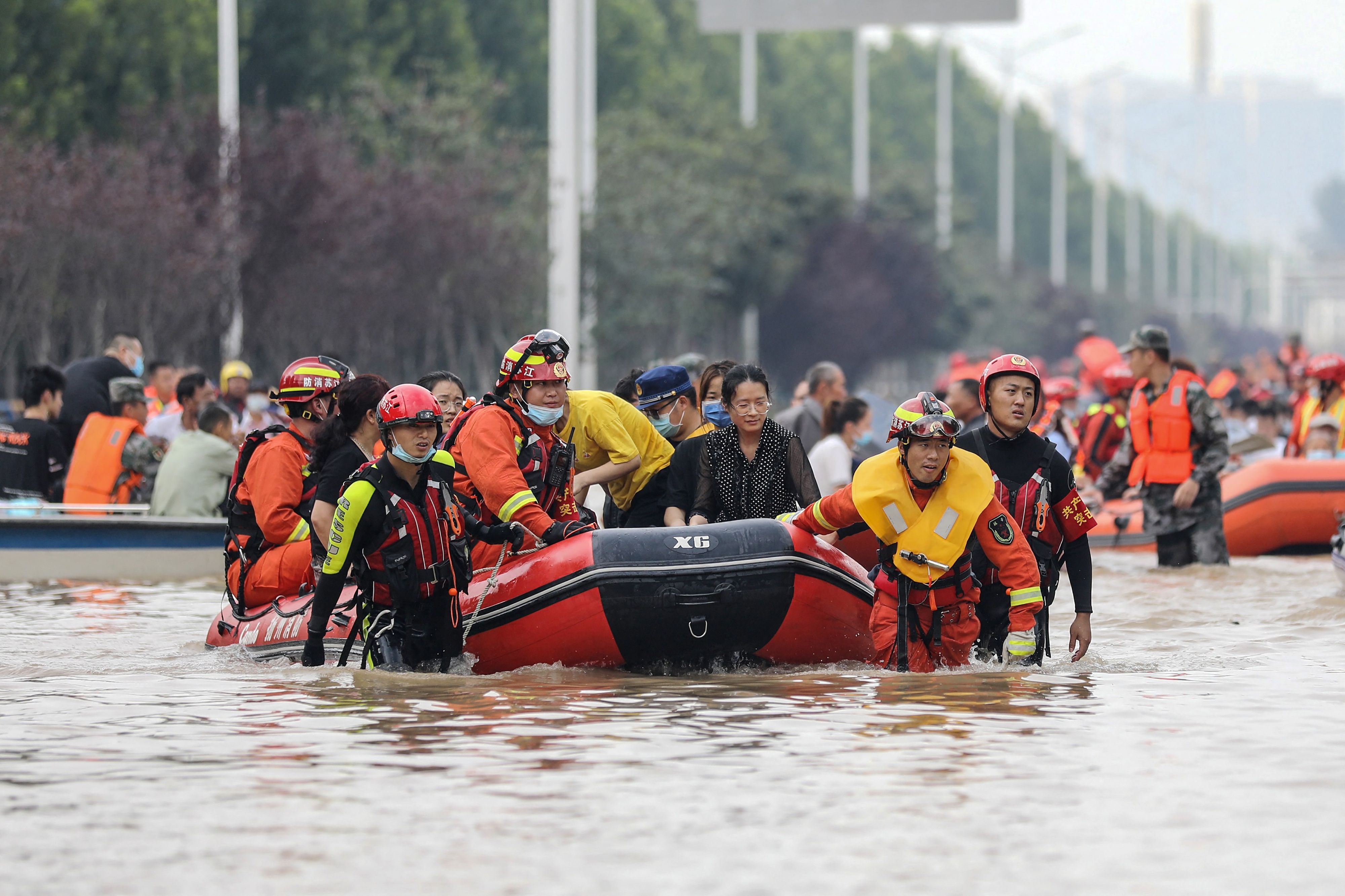 TOPSHOT - This photo taken on July 22, 2021 shows rescuers of the Fire and Rescue department from China's eastern city of Yangzhou evacuating people from a hospital following heavy rains in Zhengzhou, in China's Henan province. (Photo by STR / AFP) / China OUT