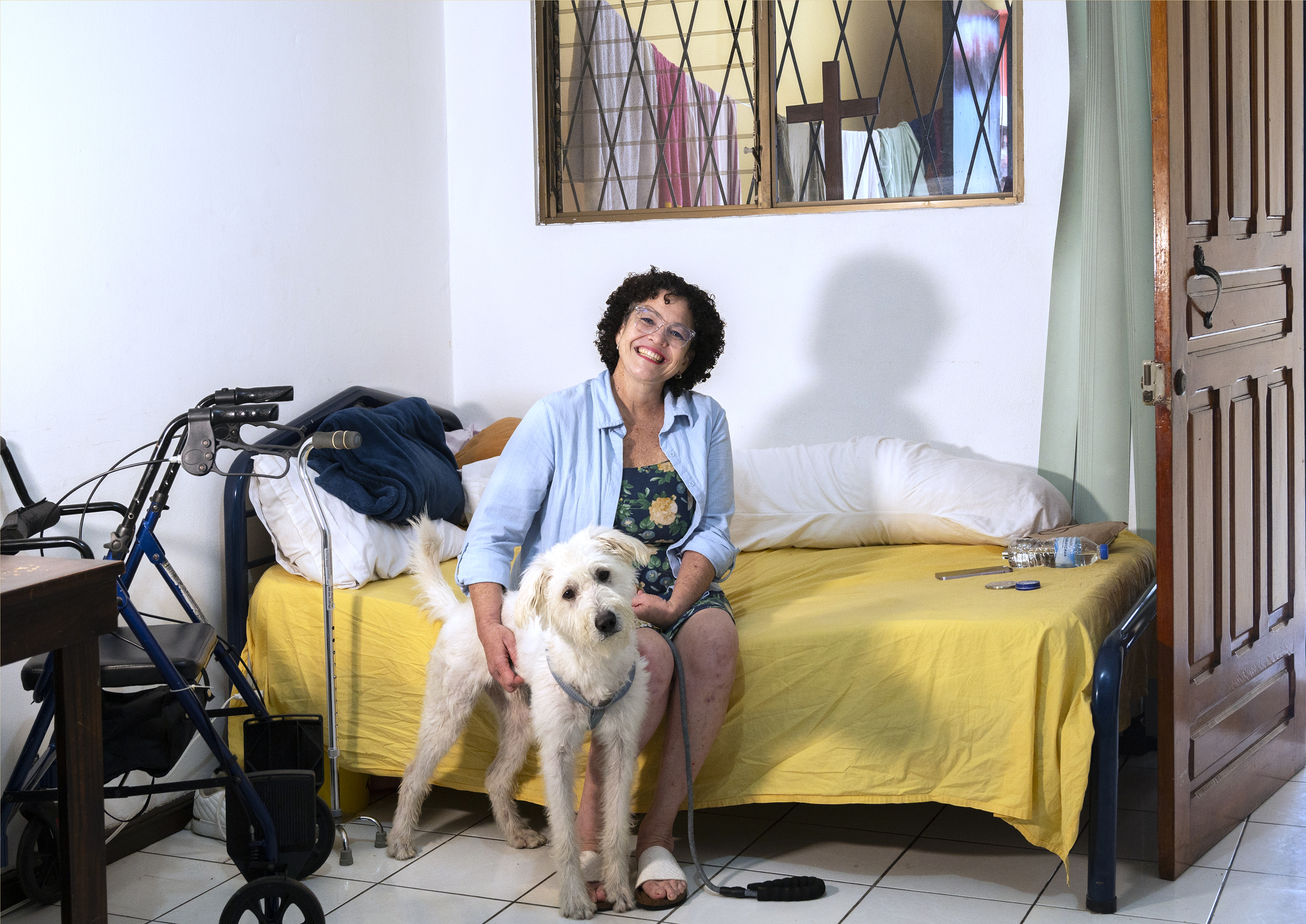 Marilyn Chaves es una paciente cáncer, de 43 años, quien posa con su perro, en su casa, en San Francisco de Dos Ríos.