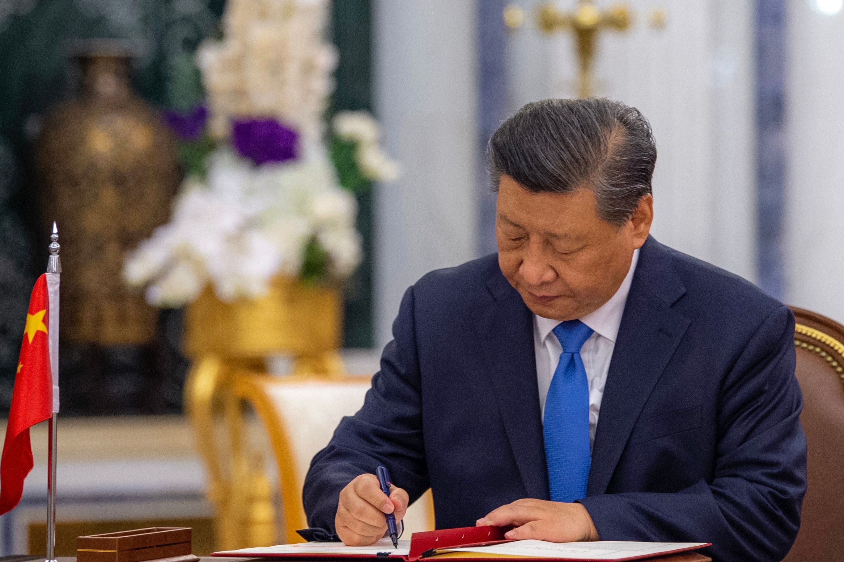This handout picture provided by the Saudi Royal Palace shows Chinese President Xi Jinping signing an agreement with Saudi King Salman bin Abdulaziz (not pictured), in the capital Riyadh, on December 8, 2022. - Agreements worth about $30 billion were being signed today, Saudi state media said, as China seeks to shore up its Covid-hit economy and as the Saudis, long-term US allies, push to diversify their economic and political alliances. (Photo by BANDAR AL-JALOUD / various sources / AFP) / RESTRICTED TO EDITORIAL USE - MANDATORY CREDIT "AFP PHOTO / SAUDI ROYAL PALACE / BANDAR AL-JALOUD" - NO MARKETING - NO ADVERTISING CAMPAIGNS - DISTRIBUTED AS A SERVICE TO CLIENTS