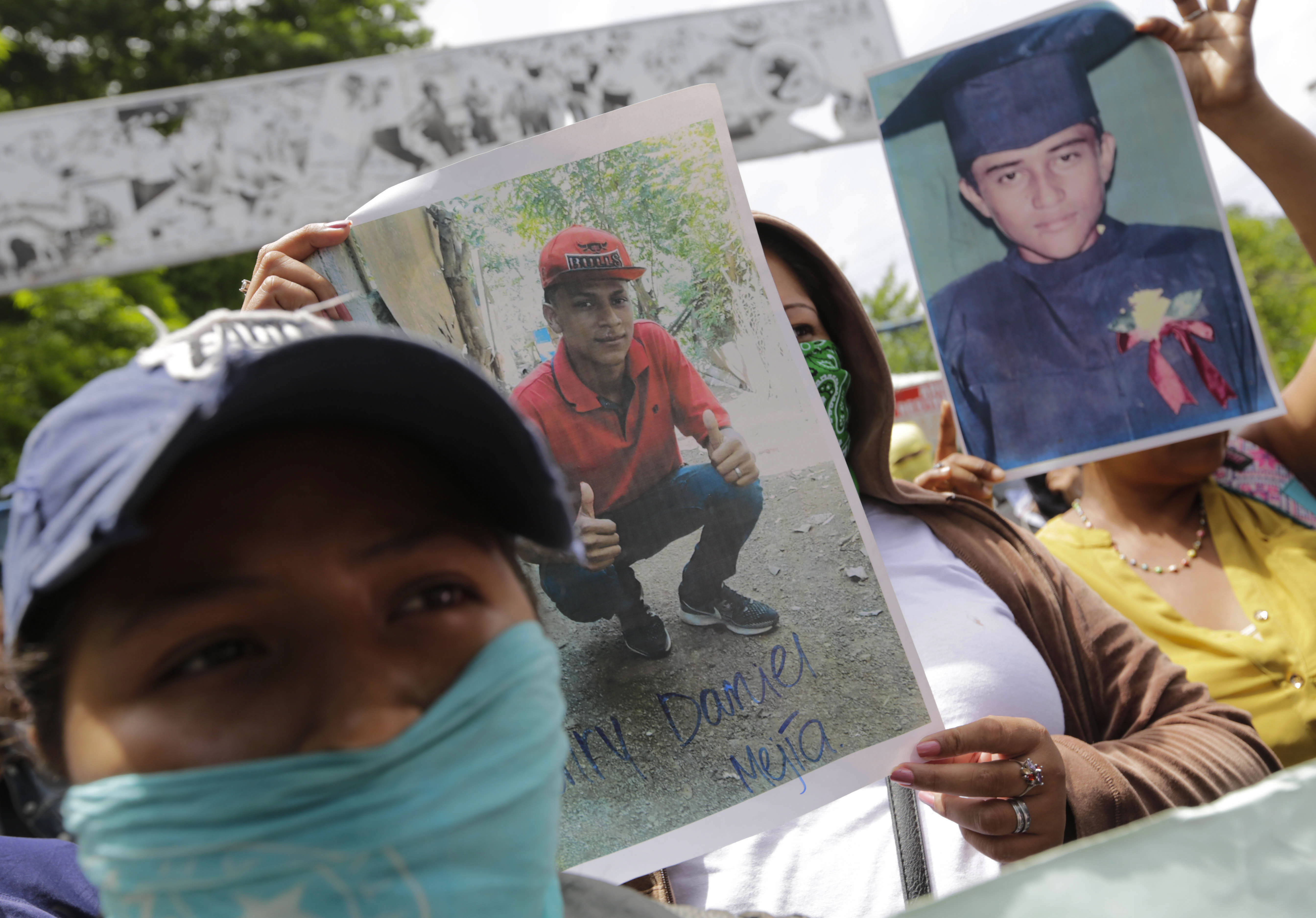 Relatives of imprisoned protesters, with their faces covered, hold their portraits as they demand their release outside "El Chipote" prison in Managua, on July 2, 2018.
More than 200 people have been killed and some 2,000 people have been imprisoned since the start of a popular uprising against Nicaraguan President Daniel Ortega in April. / AFP PHOTO / INTI OCON