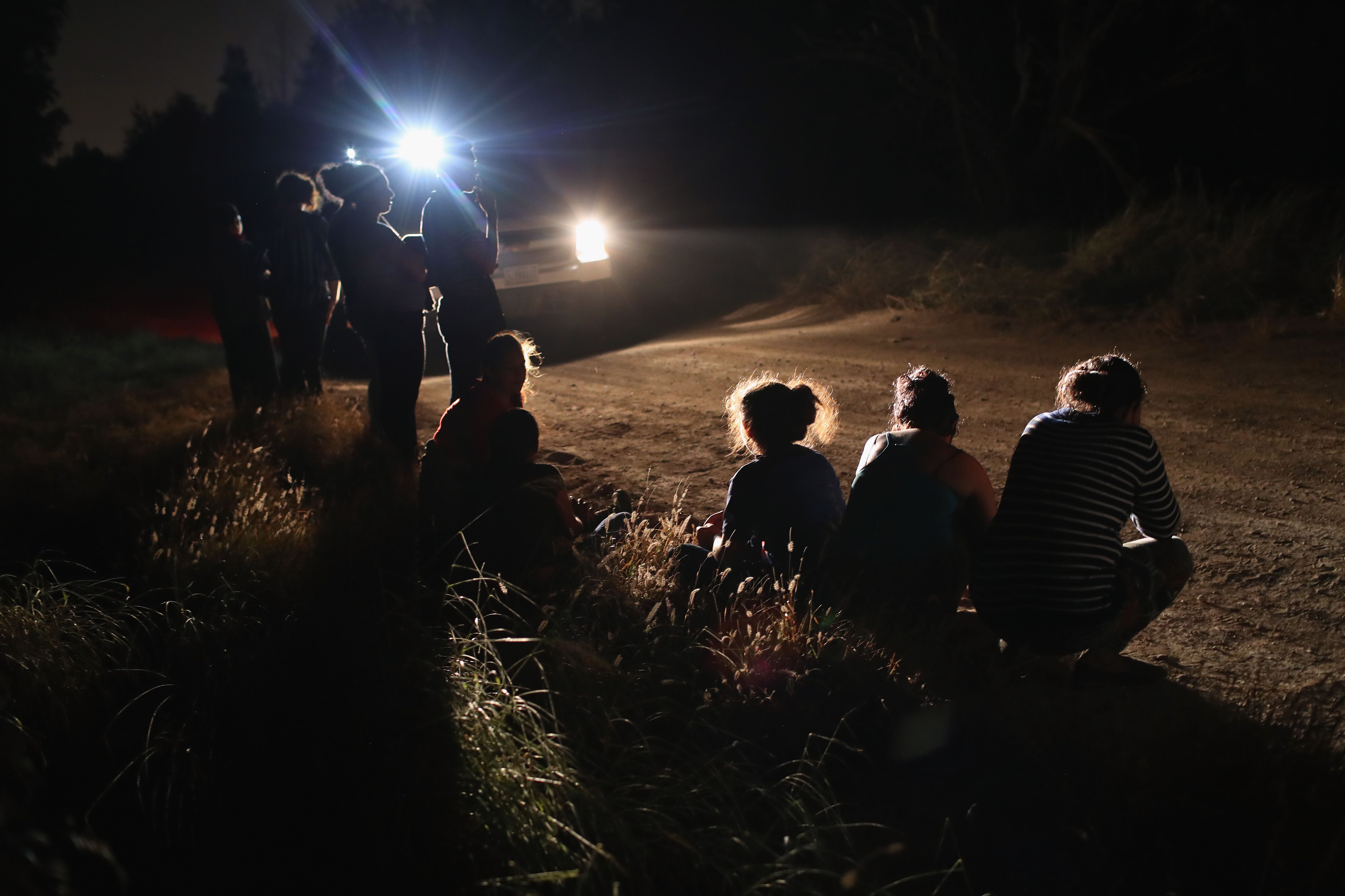 MCALLEN, TX - JUNE 12: A U.S. Border Patrol vehicle illuminates a group of Central American asylum seekers before taking them into custody near the U.S.-Mexico border on June 12, 2018 in McAllen, Texas. The group of women and children had rafted across the Rio Grande from Mexico and were detained by U.S. Border Patrol agents before being sent to a processing center for possible separation. Customs and Border Protection (CBP) is executing the Trump administration's zero tolerance policy towards undocumented immigrants. U.S. Attorney General Jeff Sessions also said that domestic and gang violence in immigrants' country of origin would no longer qualify them for political asylum status. John Moore/Getty Images/AFP
== FOR NEWSPAPERS, INTERNET, TELCOS & TELEVISION USE ONLY ==