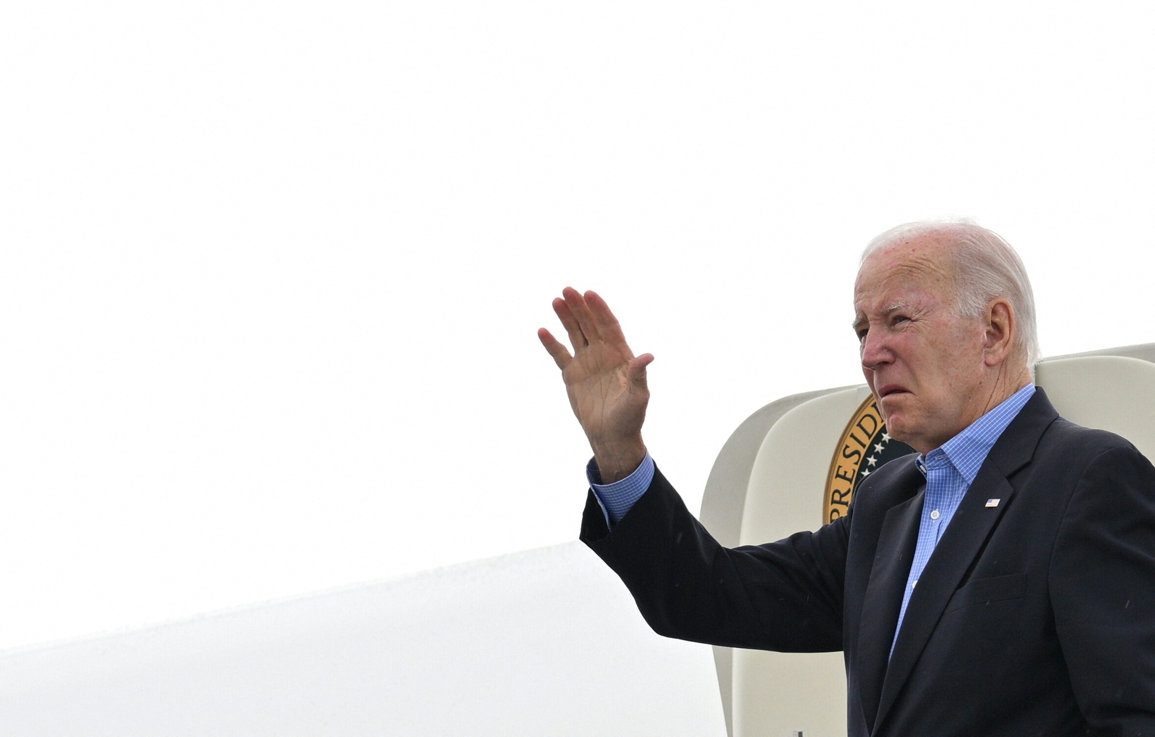 US President Joe Biden waves while boarding Air Force One at Reno-Tahoe International Airport in Reno, Nevada, on August 21, 2023, as he departs for Hawaii. The Bidens are expected to meet with first responders, survivors, and local officials following deadly wildfires in Maui. (Photo by Mandel NGAN / AFP)