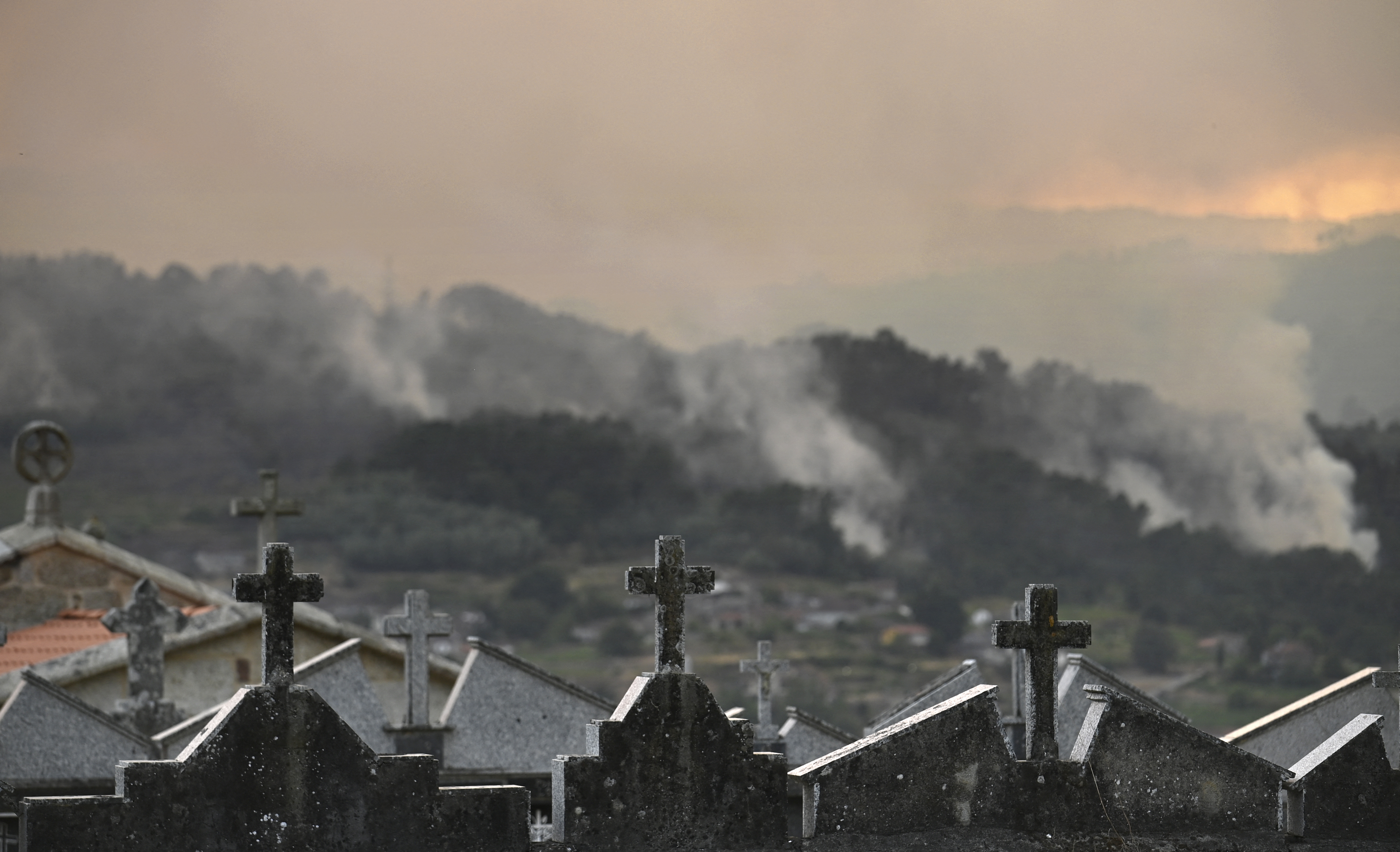 A wildfire burns near the village of Esposende, in the northwestern Spanish municipality of Cenlle, on August 17, 2025. Spain is entering its third week of heatwave alerts and firefighters are continuing to battle blazes in the northwest and west of the country, with army units deployed to help contain the flames. France and Italy had earlier sent water bombers to an air base near Salamanca to help with the firefighting efforts. (Photo by MIGUEL RIOPA / AFP)