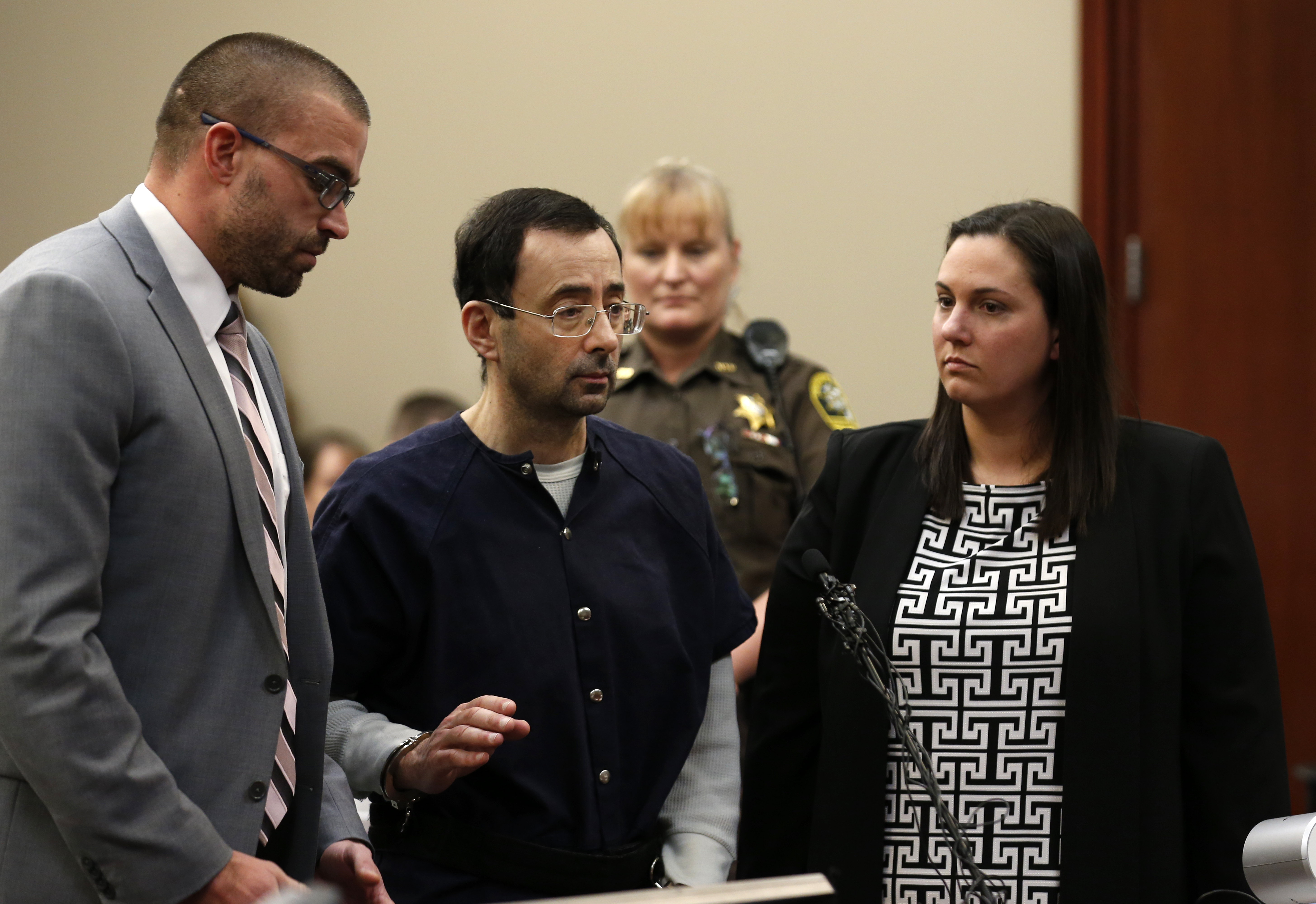 Former Michigan State University and USA Gymnastics doctor Larry Nassar (C) with defense attorneys Matt Newberg (L) and Molly Blythe (R) during the sentencing phase in Ingham County Circuit Court on January 24, 2018 in Lansing, Michigan.
Disgraced former USA Gymnastics doctor Larry Nassar was sentenced to 40 to 175 years in prison on Wednesday for sexually abusing scores of young girls under the guise of medical treatment. "I've just signed your death warrant," Judge Rosemarie Aquilina said as she handed down the sentence after a week of gut-wrenching testimony by over 150 of Nassar's victims.
/ AFP PHOTO / JEFF KOWALSKY