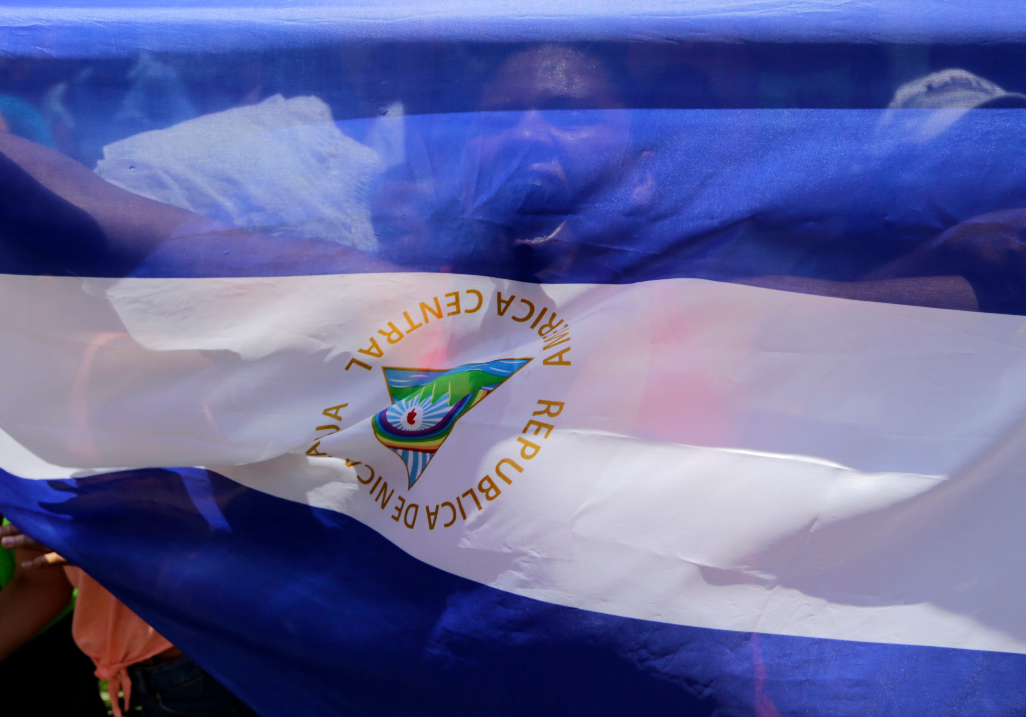 Una mujer detrás de una bandera nicaragüense grita lemas en el barrio de Monimbo, en Masaya, a unos 35 km de Managua, el 21 de junio de 2018.
Obispos nicaragüenses llegaron a la ciudad –que esta semana se declaró en rebelión al gobierno del presidente Daniel Ortega– "para evitar otra masacre" como lo fue bajo un ataque "desproporcionado" de la policía y las fuerzas paramilitares, que usaban rifles de francotirador AK47 y Dragunov contra los residentes civiles, dijo un grupo de Derechos Humanos. AFP