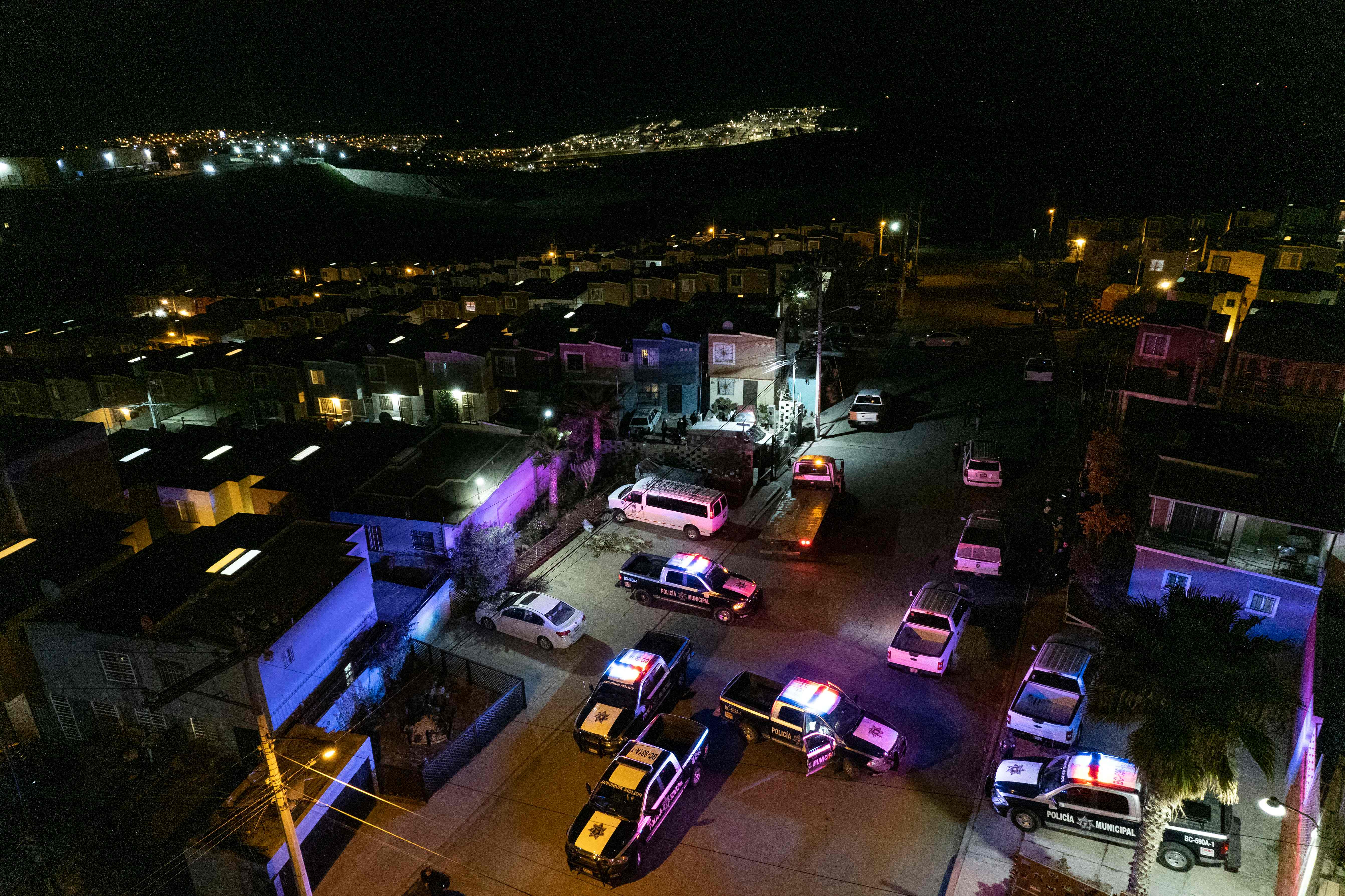 This aerial image taken on January 23, 2022 shows police cars guarding the crime scene where journalist Lourdes Maldonado was murder in Santa Fe, Tijuana's outskirts, Baja California, Mexico. - A journalist was killed in Tijuana January 23, 2022, the local prosecutor said, the second media worker murdered in less than a week in the Mexican city on the US border. (Photo by Guillermo Arias / AFP)