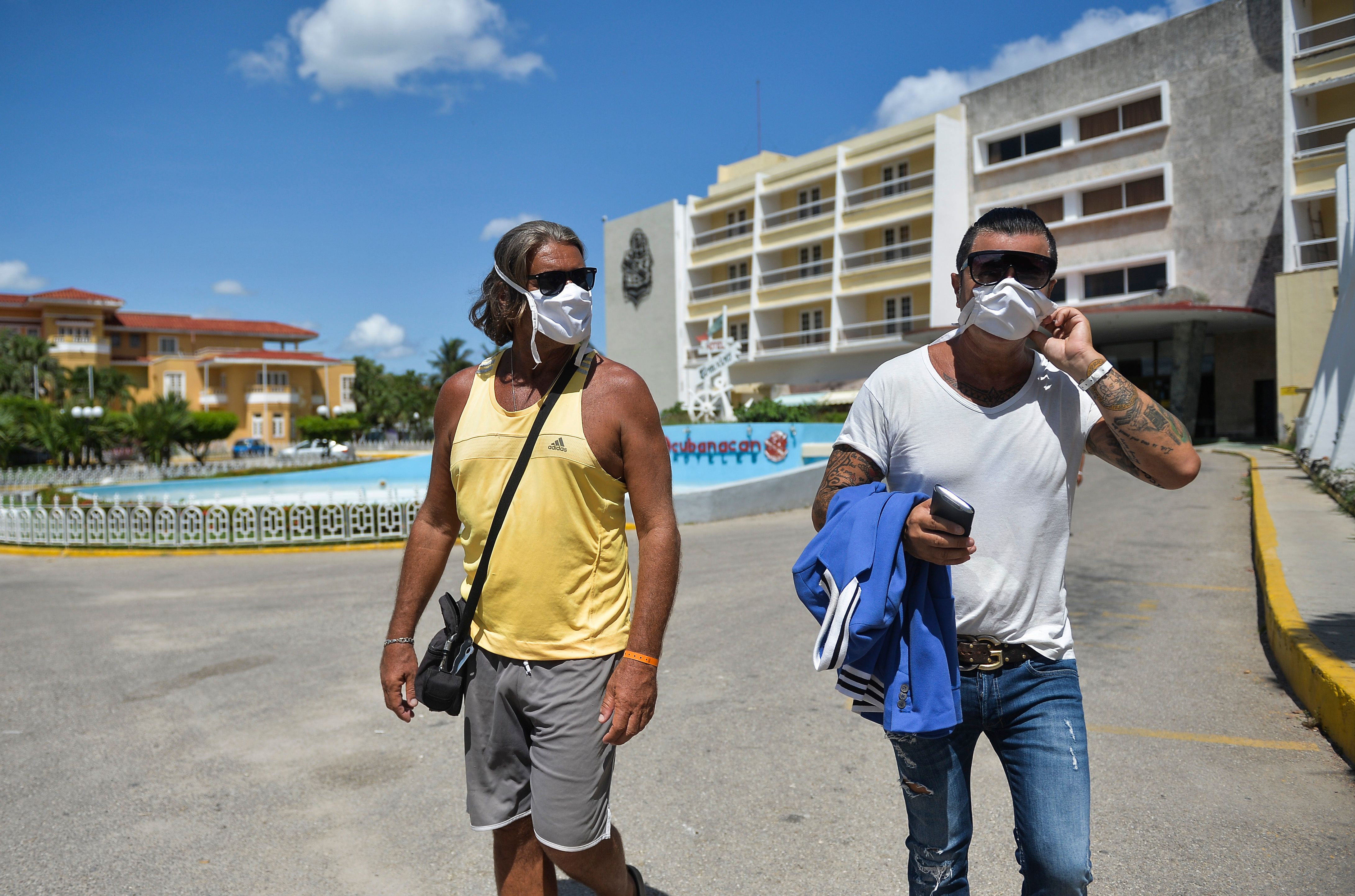 Italian tourists walk outside a hotel in Havana on May 30, 2020, where they spend the quarantine amid the new coronavirus pandemic. (Photo by Yamil LAGE / AFP)