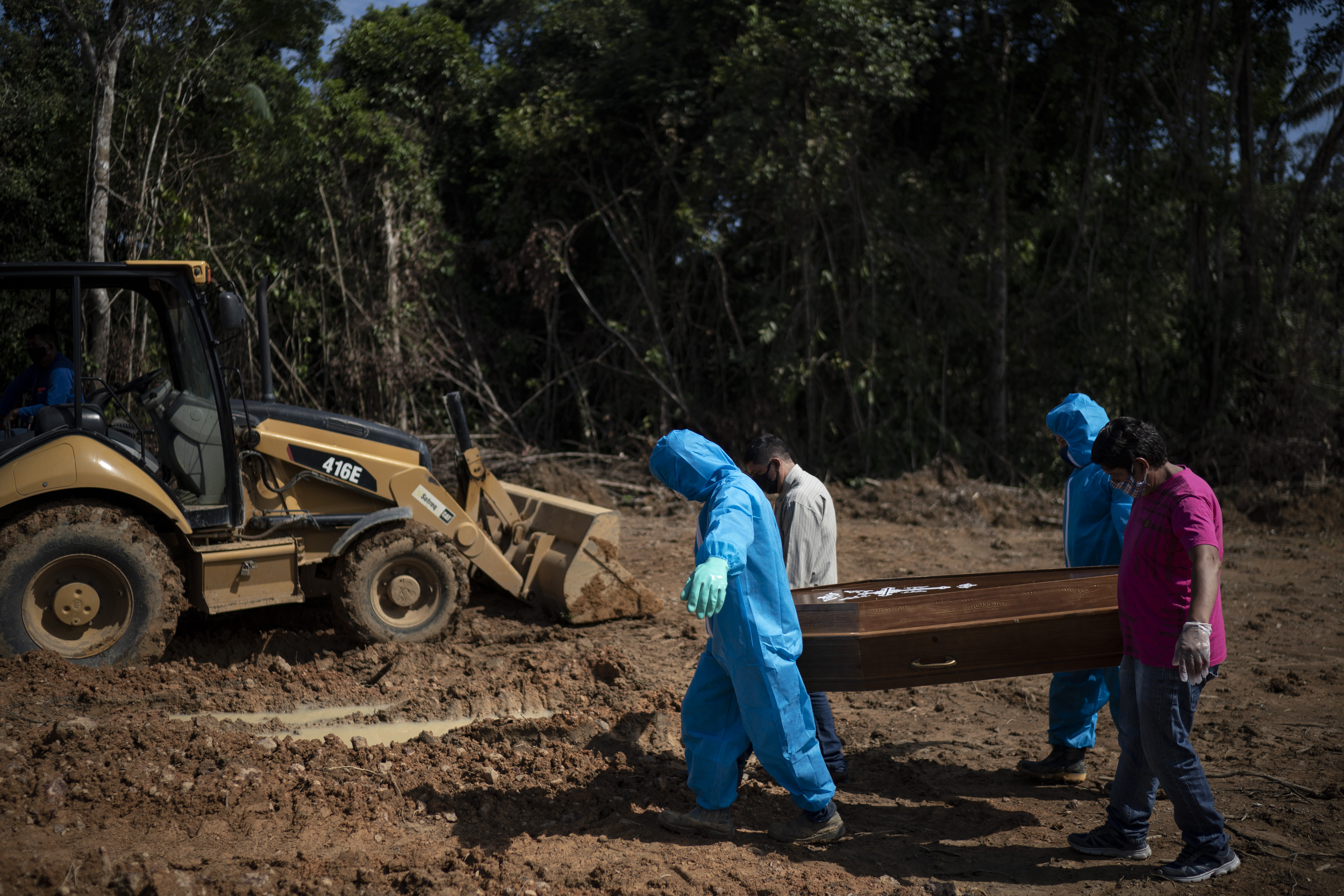 Relatives of Sebastiao de Araujo help cemetery workers, wearing protective clothing, carry his coffin to be buried in a section for COVID-19 victims at the Nossa Senhora Aparecida cemetery in Manaus, Brazil, Monday, May 11, 2020. (AP Photo/Felipe Dana)