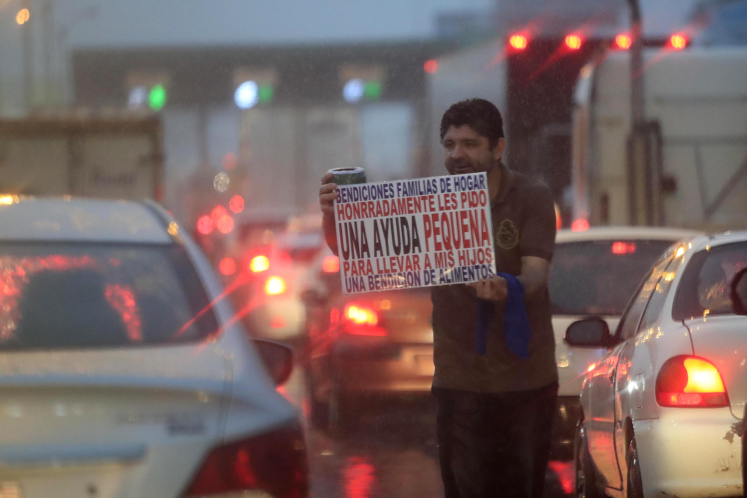 Este hombre pedía ayuda en junio pasado. Especialistas consideran que se debería ayudar a los hogares pobres pasar la actual alza en el costo de los alimentos.