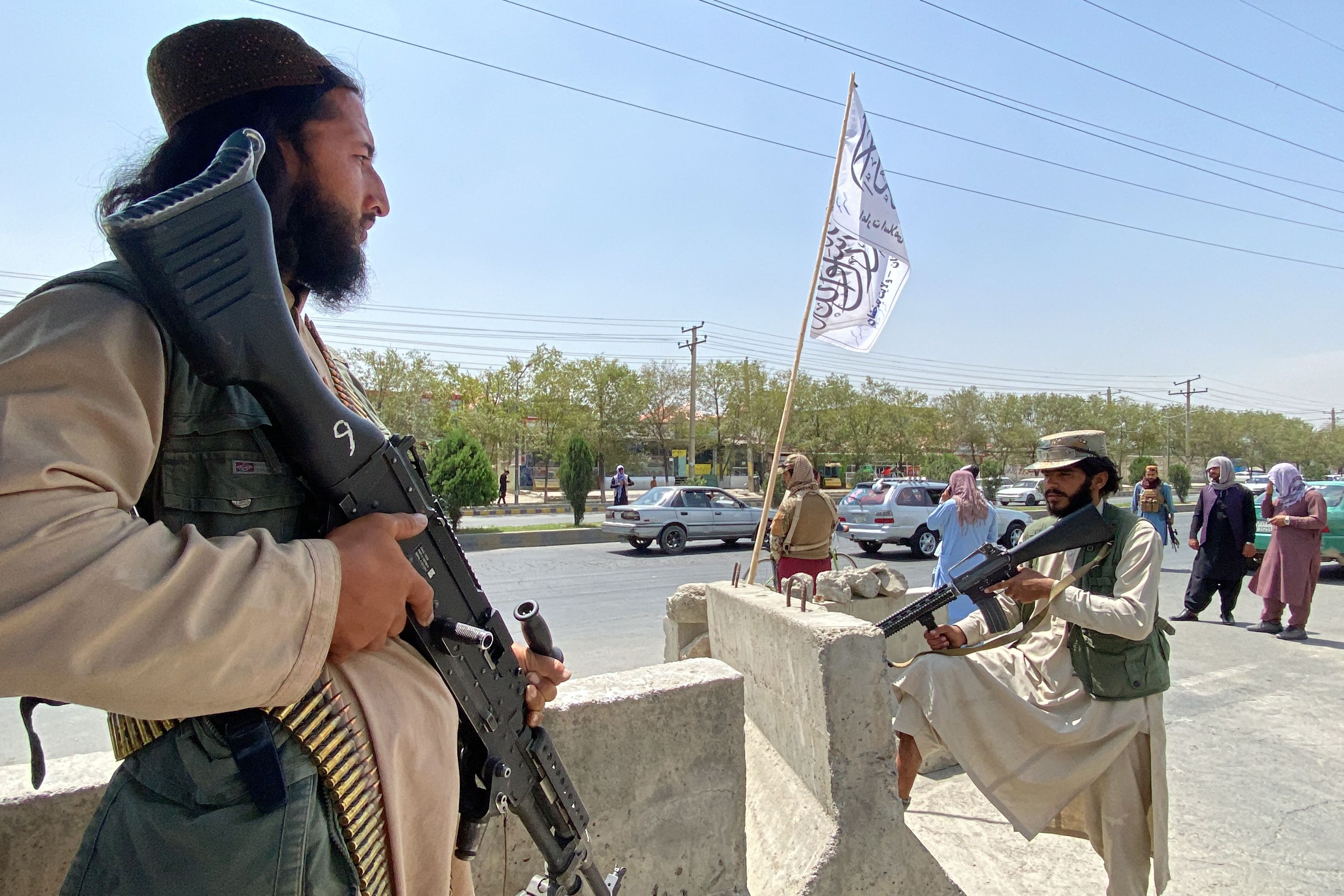 TOPSHOT - Taliban fighters stand guard at an entrance gate outside the Interior Ministry in Kabul on August 17, 2021. (Photo by Javed Tanveer / AFP)