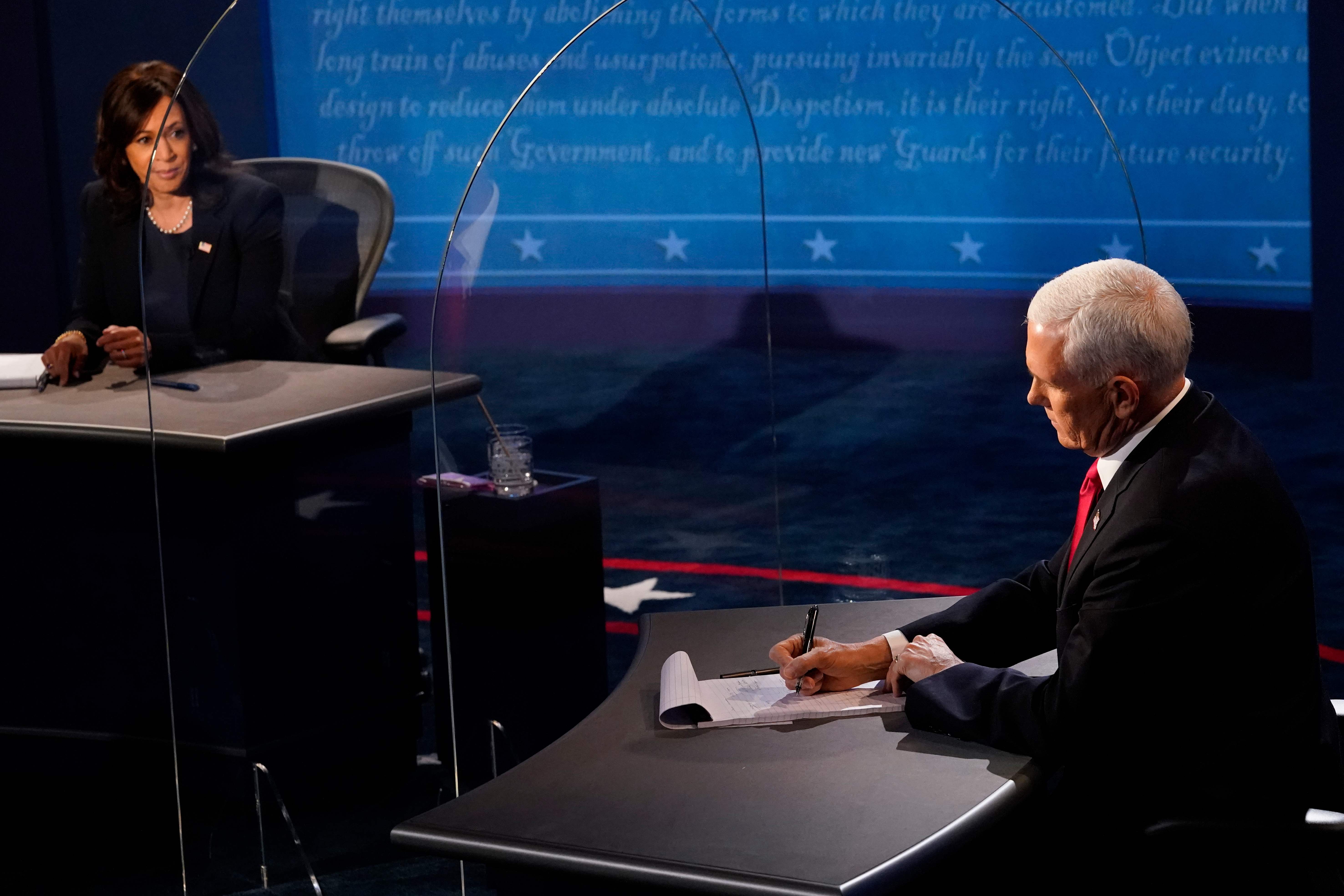 Vice President Mike Pence takes notes as he listens to Democratic vice presidential nominee Kamala Harris speak during the vice presidential debate on October 7, 2020, at Kingsbury Hall on the campus of the University of Utah in Salt Lake City. (Photo by Morry Gash / POOL / AFP)
