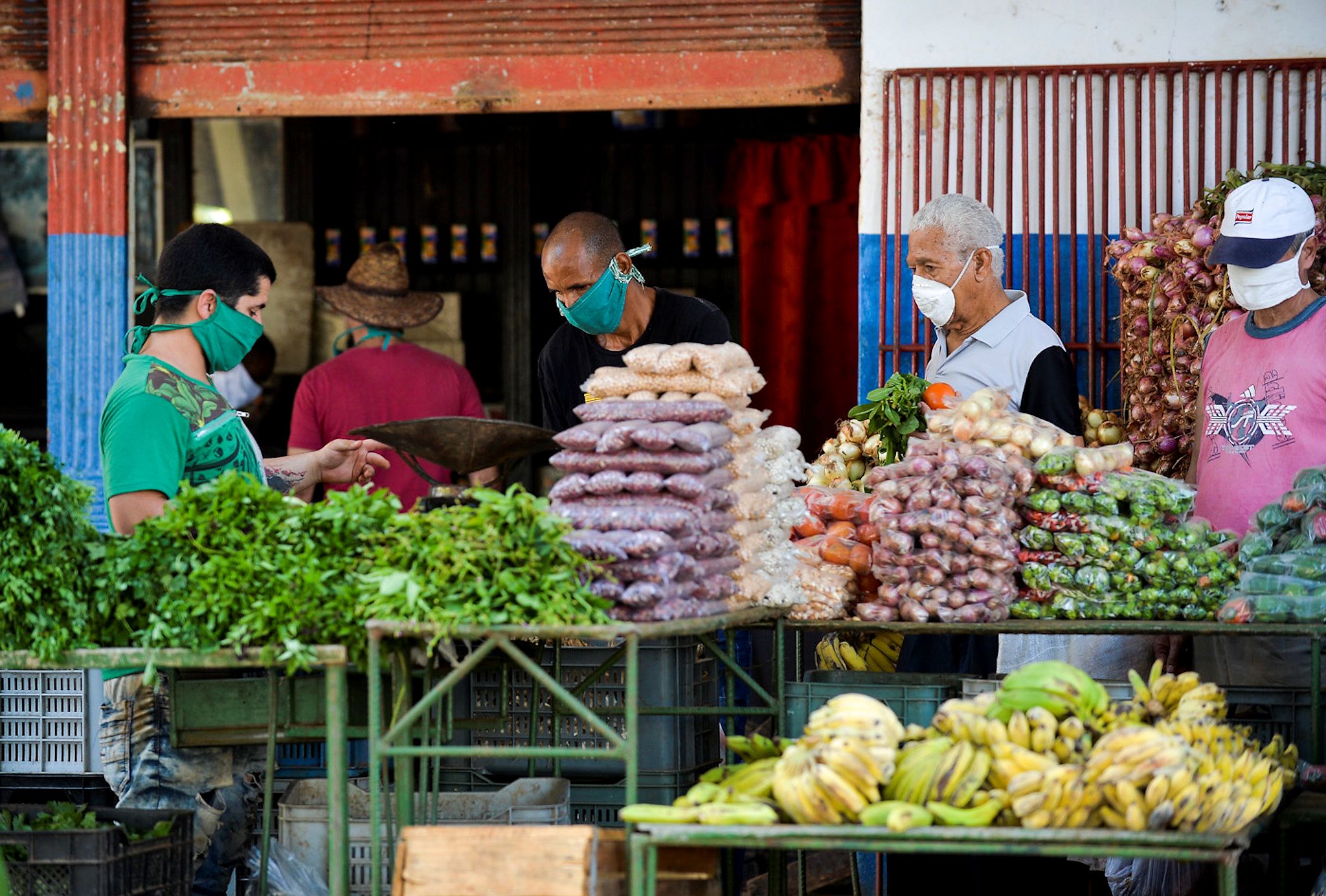 People wear face masks as they buy fruits and vegetables in Havana on April 17, 2020, amid the new coronavirus pandemic. - In addition to the COVID-19 pandemic, Cubans must also overcome food shortages, in an island that imports almost everything and suffers the consequences of the US embargo and the delay in the reform of its socialist economy. (Photo by YAMIL LAGE / AFP)