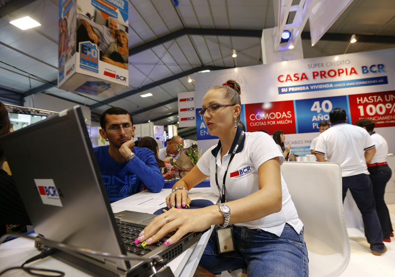 María Villalobos, del Banco de Costa Rica (BCR), atiendió a Rafael Jiménez en Expocasa 2014. Los bancos estatales son los que más han contraído el crédito en dólares. Foto: Mayela López