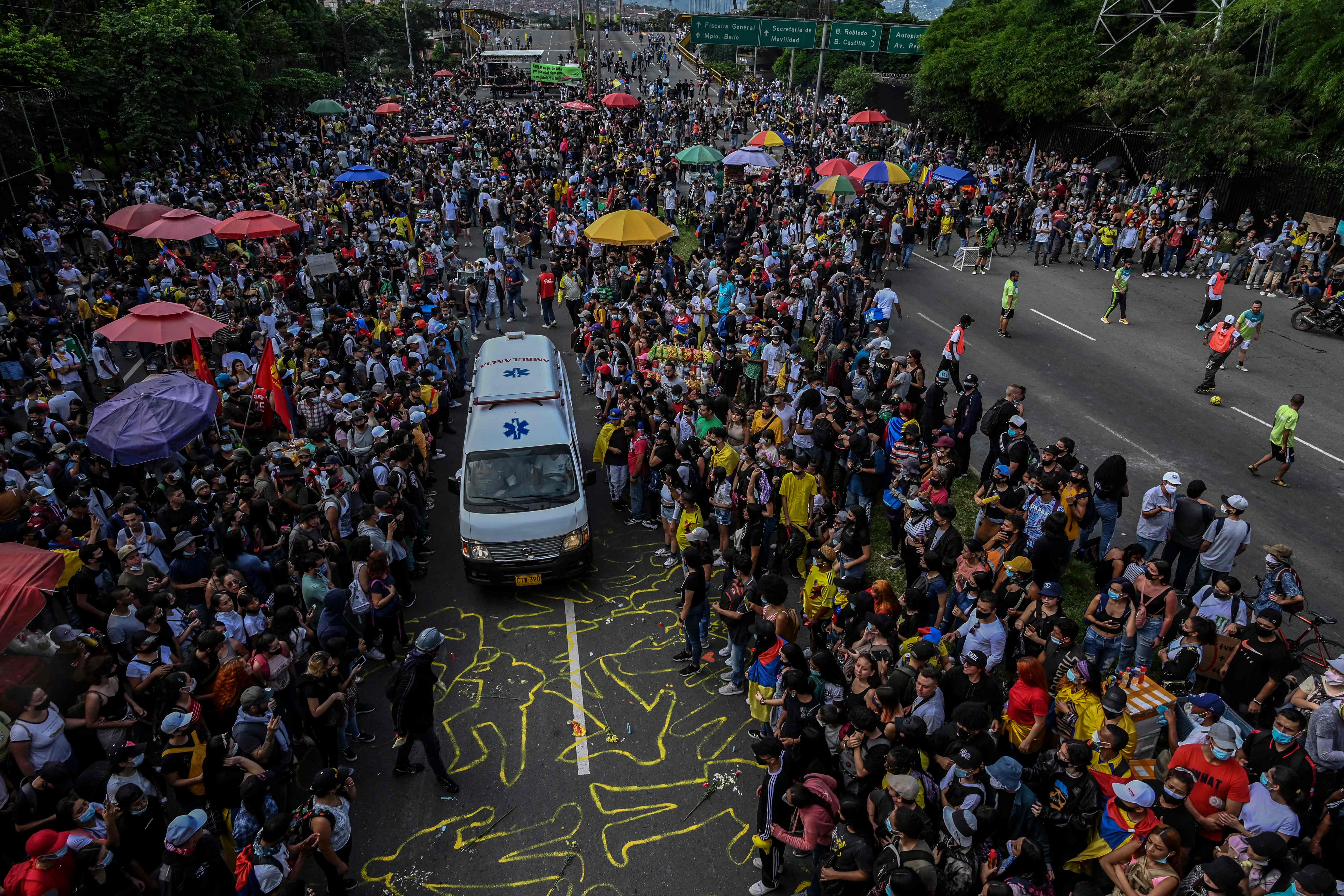 Demonstrators allow an ambulance to pass by during a new protest against the government in Medellin, Colombia on May 12, 2021. - At least 42 people have been killed in near-daily protests against the Colombian government since April 28, the country's human rights ombudsman said Tuesday. The protests, initially against a proposed tax reform, soon morphed into a broader demonstration of anti-government sentiment in a country battling ongoing violence and economic hardship made worse by the coronavirus epidemic. (Photo by JOAQUIN SARMIENTO / AFP)