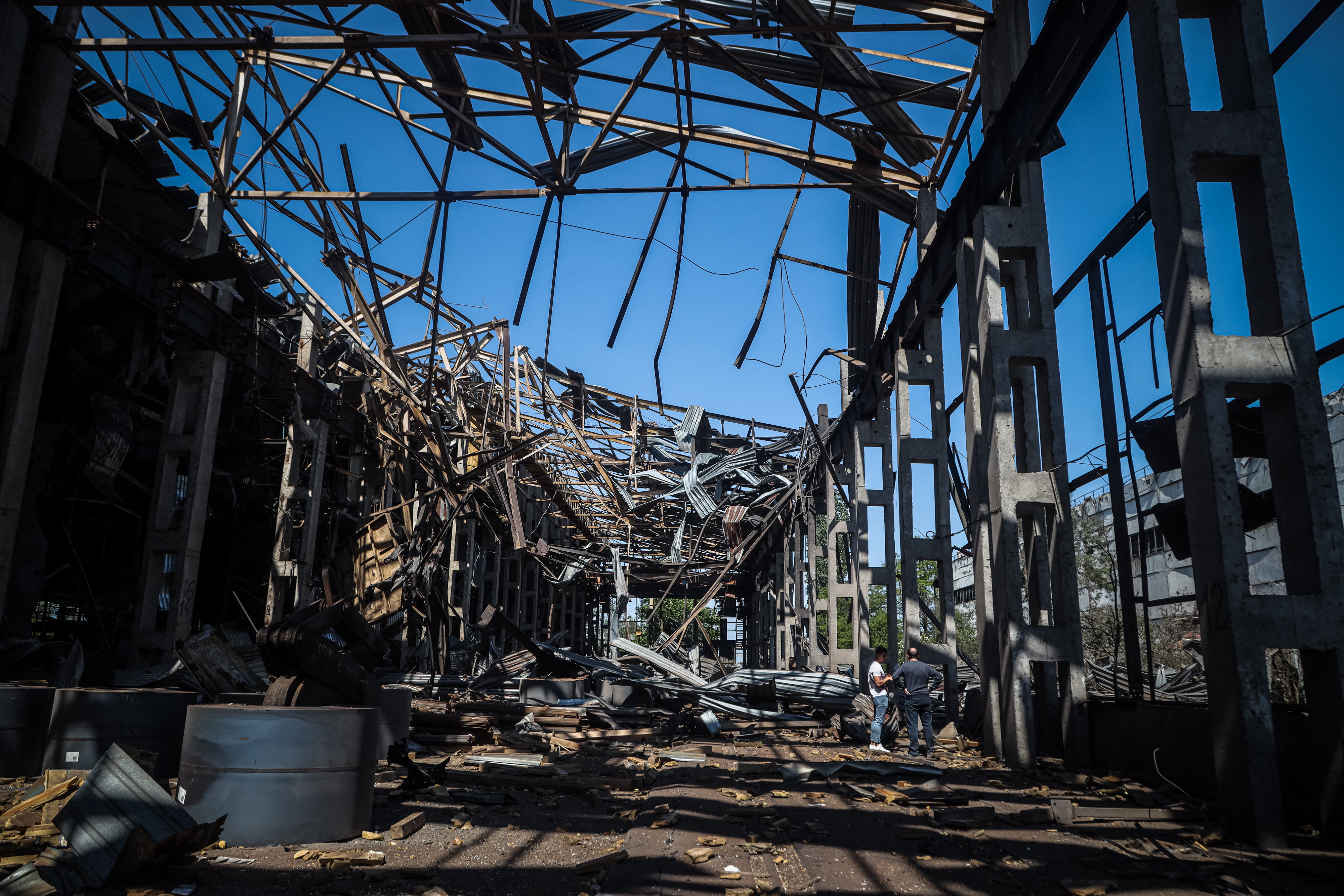 Los residentes examinan los restos de un edificio industrial que resultó dañado tras un ataque con misiles rusos en Odesa el 18 de mayo de 2023. En el ataque de este lunes, Rusia golpeó el puerto de esa localidad, en el sur de Ucrania.