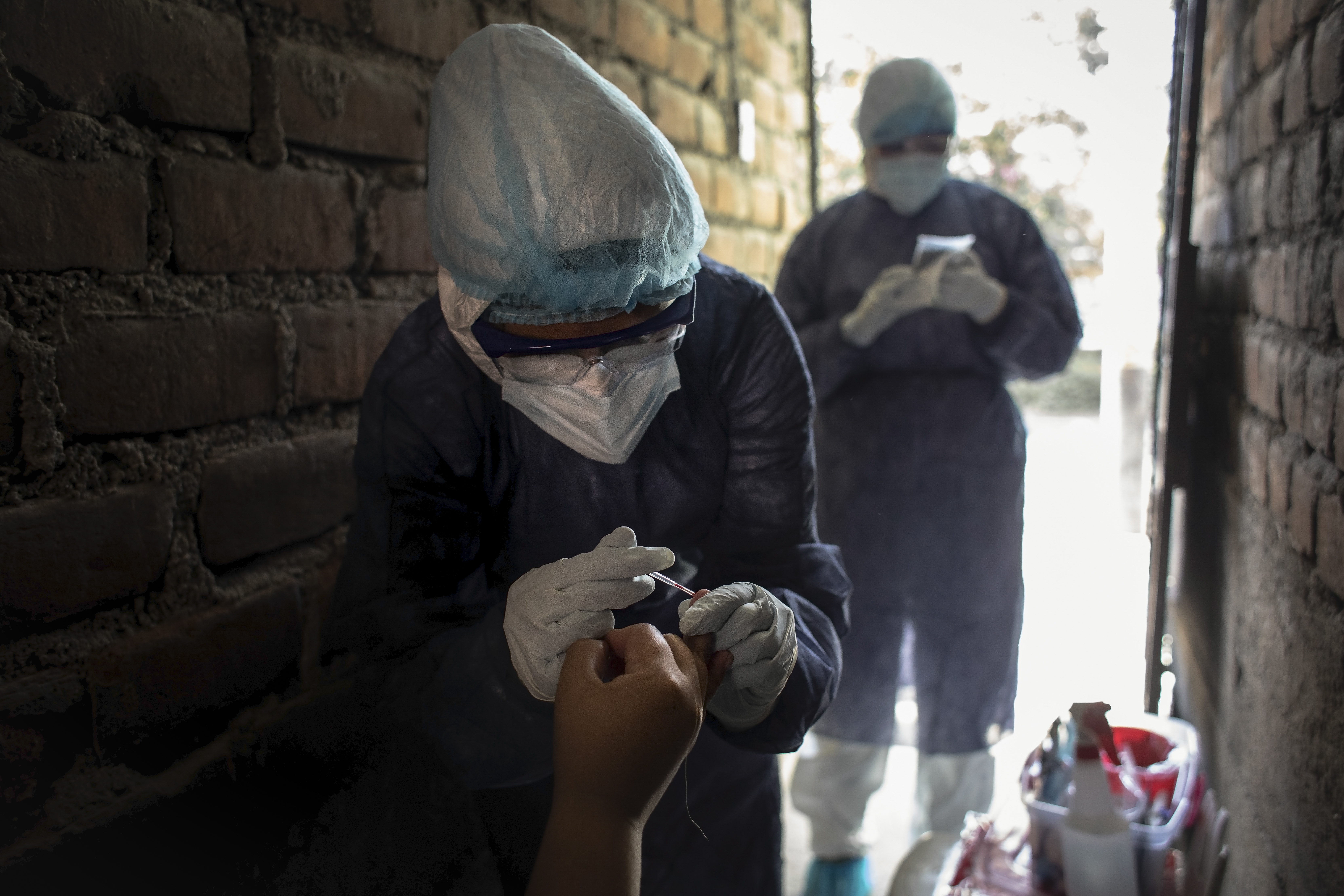 De lunes a domingo, incluidos los feriados, un equipo de médicos y tecnólogos médicos trabaja incansablemente para realizar pruebas serológicas a cada persona que reportó tener síntomas del coronavirus. Casa por casa, recorren la ciudad para descartar a los portadores del temido virus.
Son 78 grupos de respuesta rápida de la Direcciones de Redes Integradas de Salud (Diris) Lima Norte, del Ministerio de Salud, conformados por 156 profesionales de la salud. Entre ellos se encuentran la doctora Úrsula Canales y la tecnóloga médica Leslei Montoro, quienes realizan entre 10 a 15 pruebas rápidas cada día.
La situación es distinta en cada lugar. Saben que acuden a espacios donde la infección está presente y, aunque la profesión está por delante, el temor a un contagio no se disipa. Por ello, llegan una indumentaria de seguridad especial y se rocían alcohol todo el tiempo para reducir las posibilidades de contagio.
Foto: Joel Alonzo/GEC