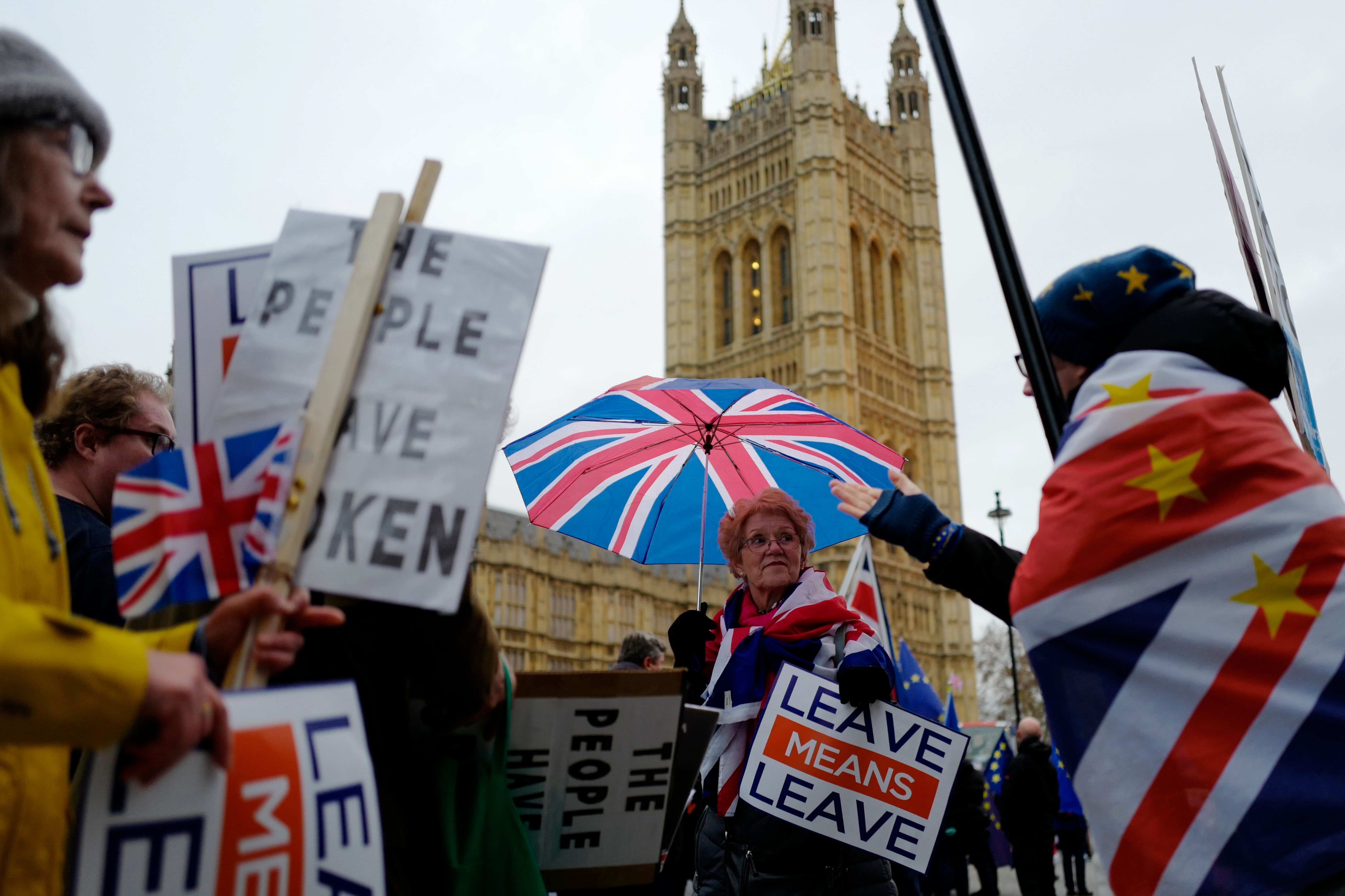 Pro and anti Brexit demonstrators protest outside Parliament as Theresa May announced a postponement of a crucial parliamentary vote on the Brexit agreement struck with EU leaders last month in London on December 10, 2018. (Photo by Tolga AKMEN / AFP)