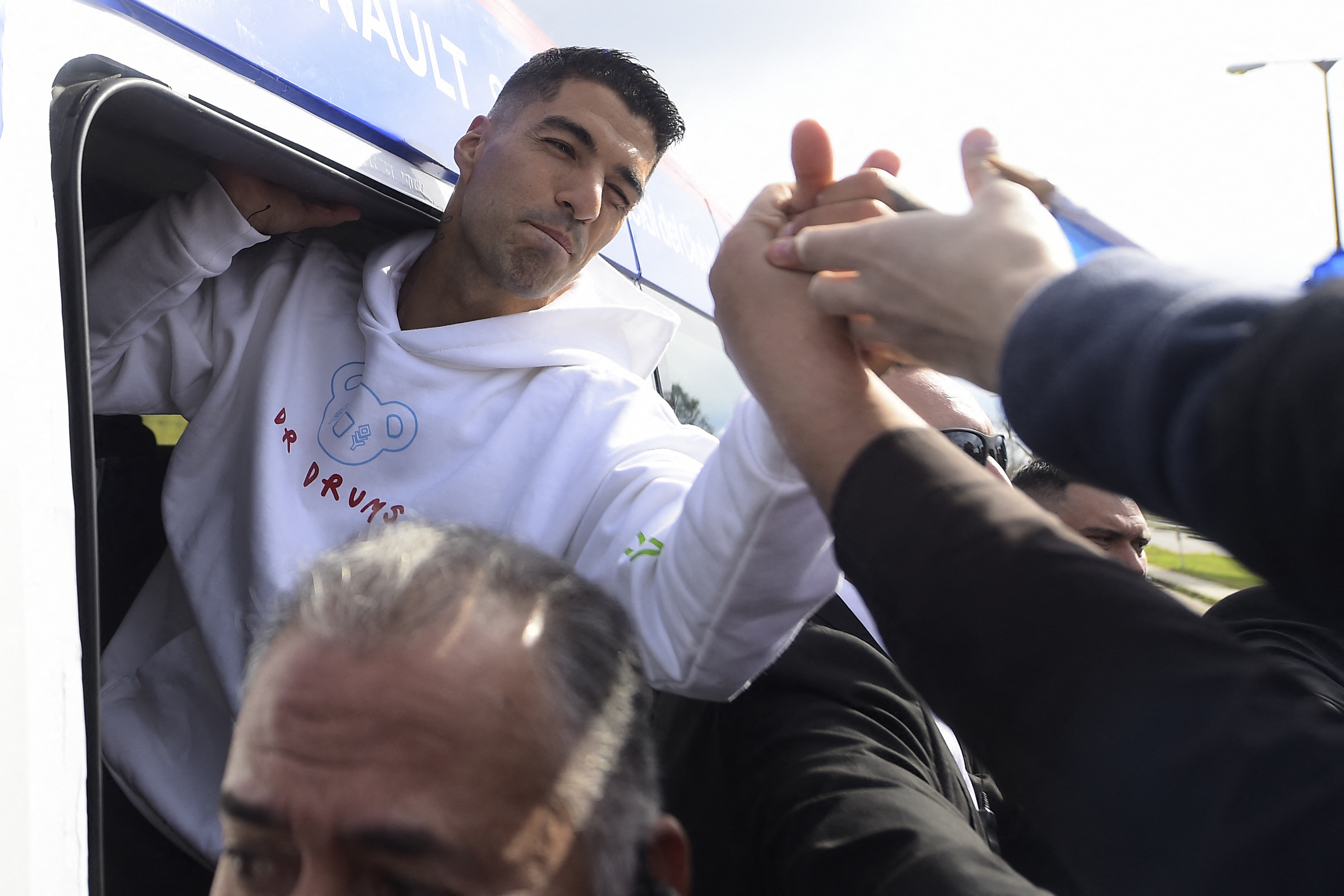 Uruguayan forward Luis Suarez greets fans during a caravan in route for a welcoming ceremony at the Gran Parque Central stadium, outside Carrasco International Airport in Ciudad de la Costa, Uruguay, on July 31, 2022. - Luis Suarez returned to Uruguay on Sunday to join Nacional, the club where he began his career 17 years ago as one of the most important strikers of his generation. (Photo by Dante Fernandez / AFP)