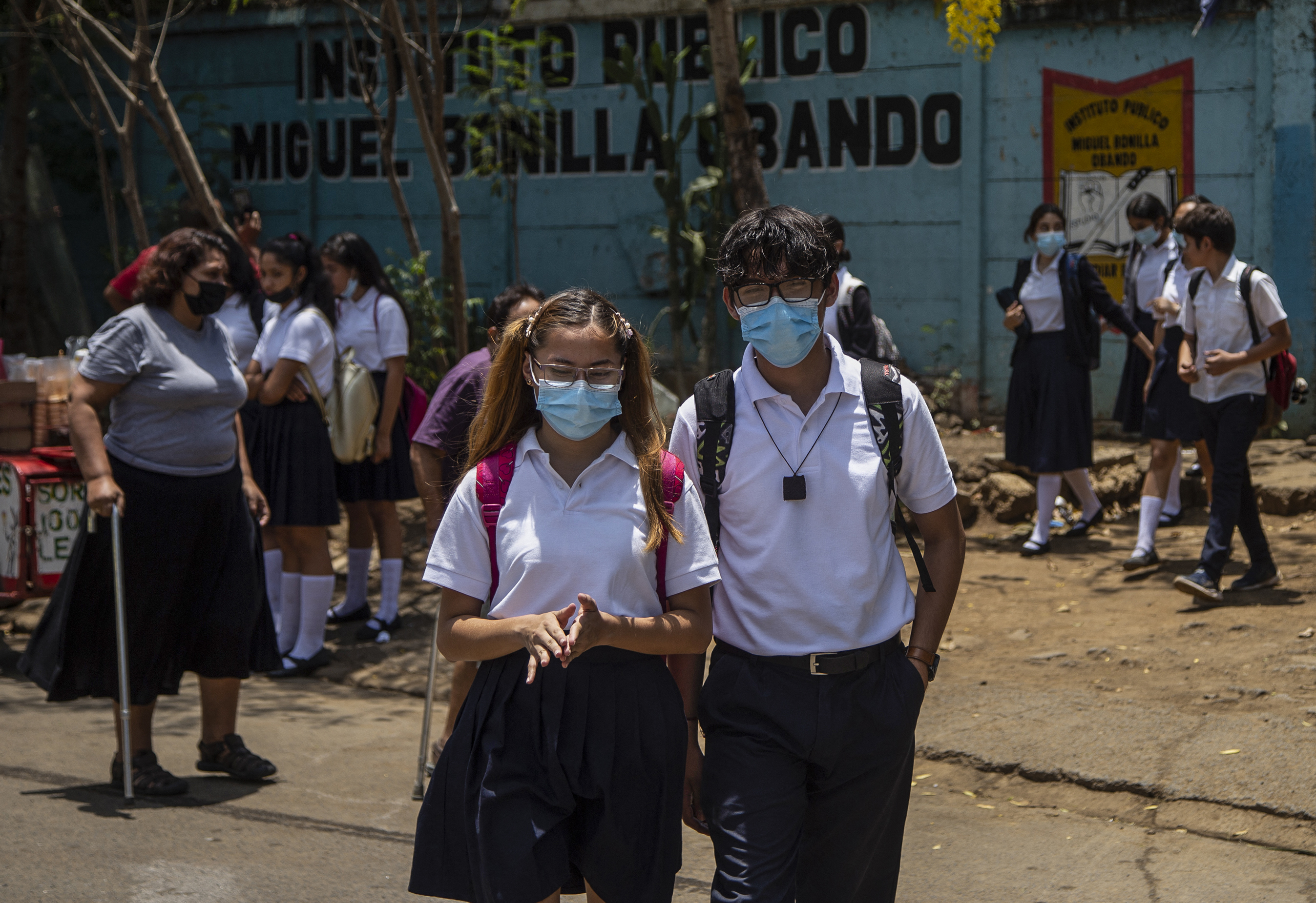 Students wearing face masks walk back to their homes from Miguel Bonilla Obando Public School in Managua, on April 29, 2021. - Several private schools in Nicaragua opted to suspend their on-site classes, amid an apparent upturn in cases of covid-19, which also affects public schools, in a country where no major pandemic containment measures were adopted. (Photo by INTI OCON / AFP)