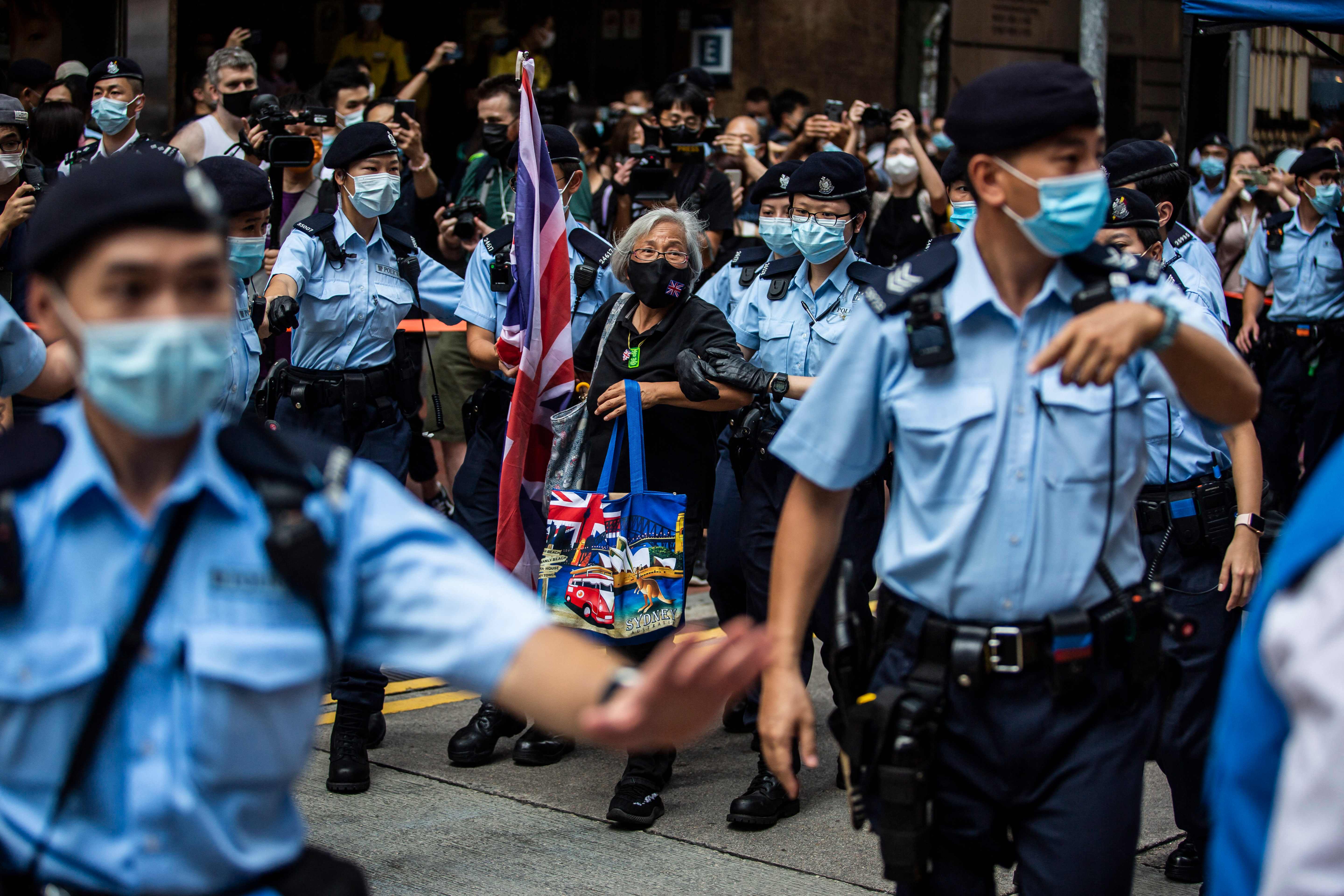 TOPSHOT - Activist Alexandra Wong (C), also known as Grandma Wong, is taken away by police while protesting on the 24th anniversary of Hong Kong's handover from Britain, in Hong Kong on July 1, 2021. (Photo by ISAAC LAWRENCE / AFP)