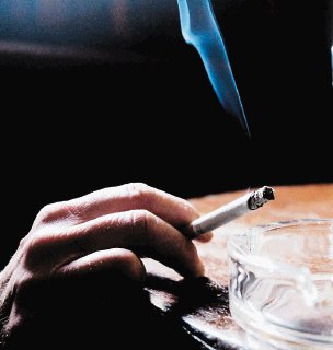A smoker enjoys a cigarette at the Duke of York pub in Belfast, Northern Ireland, Monday, Oct. 17, 2005. The British goverment announced Monday that they will introduce legislation to control smoking in all workplaces and enclosed public spaces in Northern Ireland in April 2007. (AP Photo/Peter Morrison) Drogas, Alcohol, Cervezas, Tabaco, Cigarrillos, Fumado
