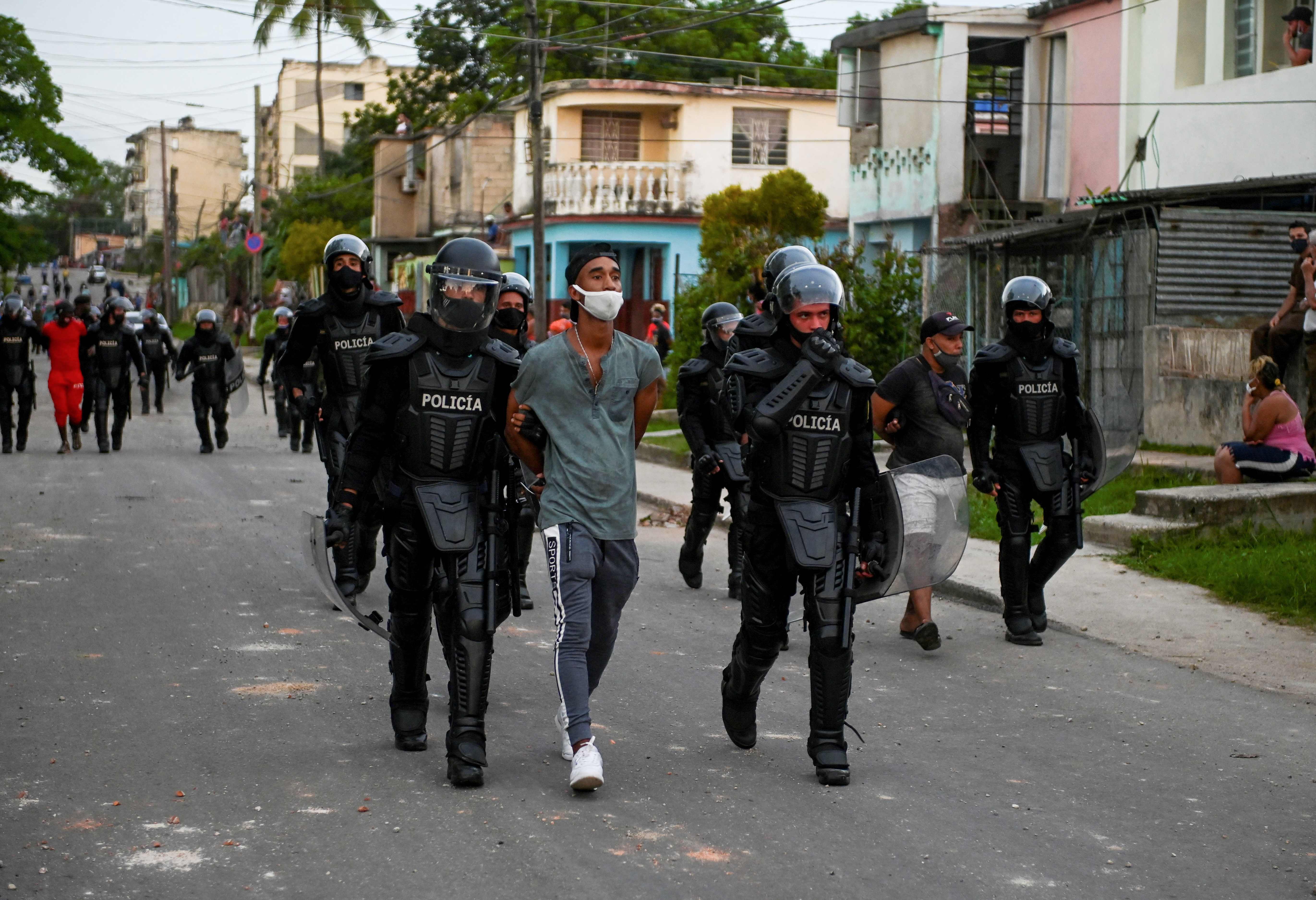 TOPSHOT - A man is arrested during a demonstration against the government of President Miguel Diaz-Canel in Arroyo Naranjo Municipality, Havana on July 12, 2021. - Cuba on Monday blamed a "policy of economic suffocation" of United States for unprecedented anti-government protests, as President Joe Biden backed calls to end "decades of repression" on the communist island. Thousands of Cubans participated in Sunday's demonstrations, chanting "Down with the dictatorship," as President Miguel D�az-Canel urged supporters to confront the protesters. (Photo by YAMIL LAGE / AFP)
