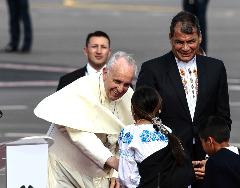 El papa Francisco saluda a dos niños indígenas junto al presidente de Ecuador, Rafael Correa (der), este domingo 5 de julio, al llegar a Quito, Ecuador, en la primera parada en su gira latinoamericana. | EFE