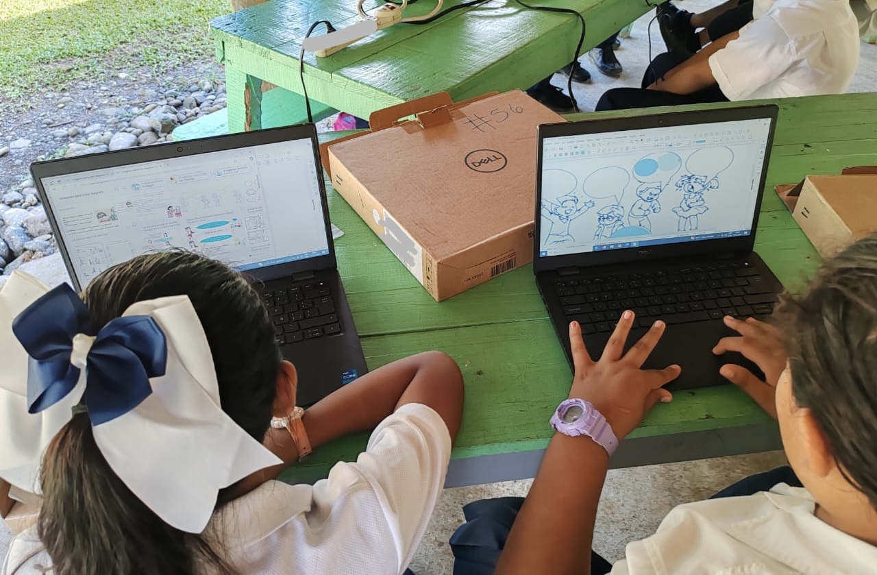 Escolares con computadora.