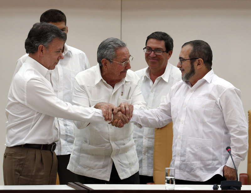 HAB202. LA HABANA (CUBA), 23/09/2015.- El presidente de Colombia Juan Manuel Santos (i), el presidente de Cuba Raúl Castro (c) y el máximo líder de las FARC, Rodrigo Londoño (d), alias "Timochenko", se dan la mano hoy, miércoles 23 de septiembre de 2015, durante un acto en La Habana (Cuba). Juan Manuel Santos y Rodrigo Londoño, alias "Timochenko", se dieron hoy un histórico apretón de manos, tras anunciar en La Habana el acuerdo alcanzado entre las partes en materia de justicia transicional, clave para la paz. Ambos posaron para la foto, junto con el presidente de Cuba, Raúl Castro, quien se situó en el medio y dio la mano a Santos y a "Timochenko", quienes tras unos segundos, también se dieron la mano; un simbólico gesto que aproxima la paz. El acuerdo sobre justicia anunciado hoy contempla entre otras cosas una amnistía para delitos políticos, la creación de un tribunal especial para la paz, y establece que la guerrilla deberá entregar las armas en un plazo de 60 días tras la firma del acuerdo definitivo. EFE/ORLANDO BARRIA