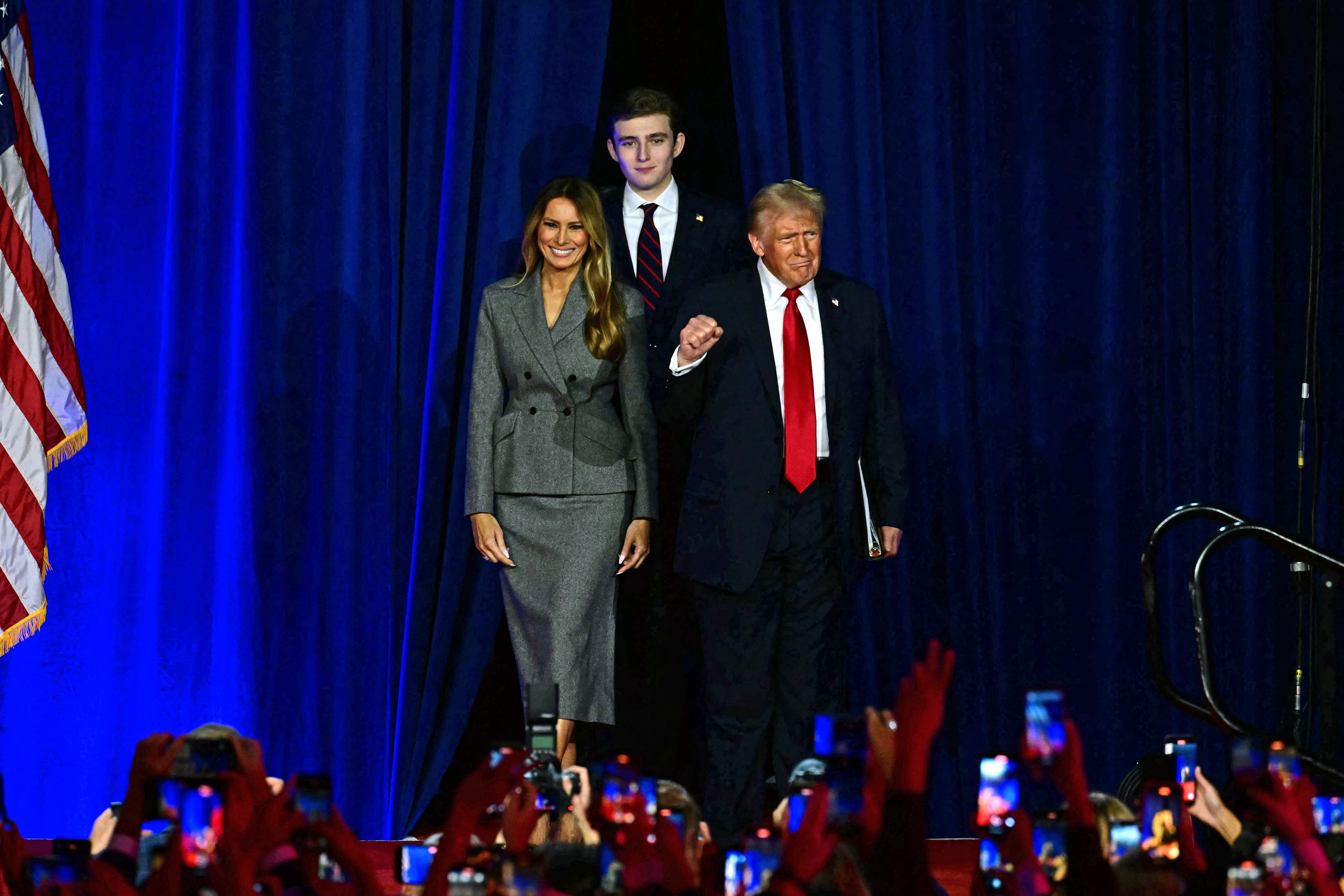 El expresidente estadounidense y candidato presidencial republicano Donald Trump (derecha) llega a un evento de la noche de las elecciones junto a la exprimera dama estadounidense Melania Trump y su hijo Barron Trump en el Centro de Convenciones de West Palm Beach, Florida.