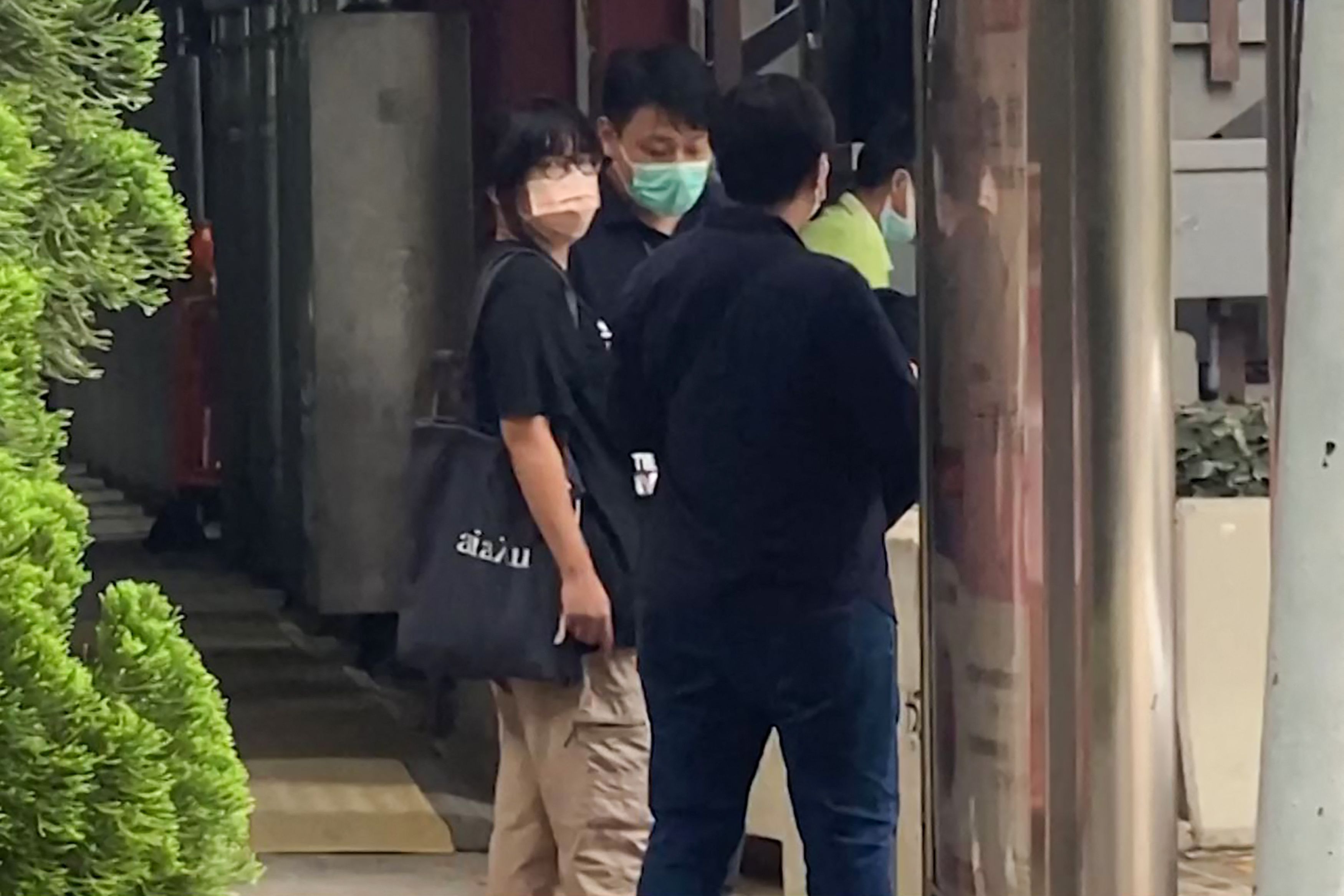 TOPSHOT - This video frame grab taken from AFPTV footage shows Chow Hang-tung (L), barrister and a leader of the Hong Kong Alliance in Support of Patriotic Democratic Movements of China, being led away by plainclothes police officers after being detained in Hong Kong on June 4, 2021, the anniversary of Beijing's deadly Tiananmen crackdown. (Photo by Xinqi SU / AFPTV / AFP)