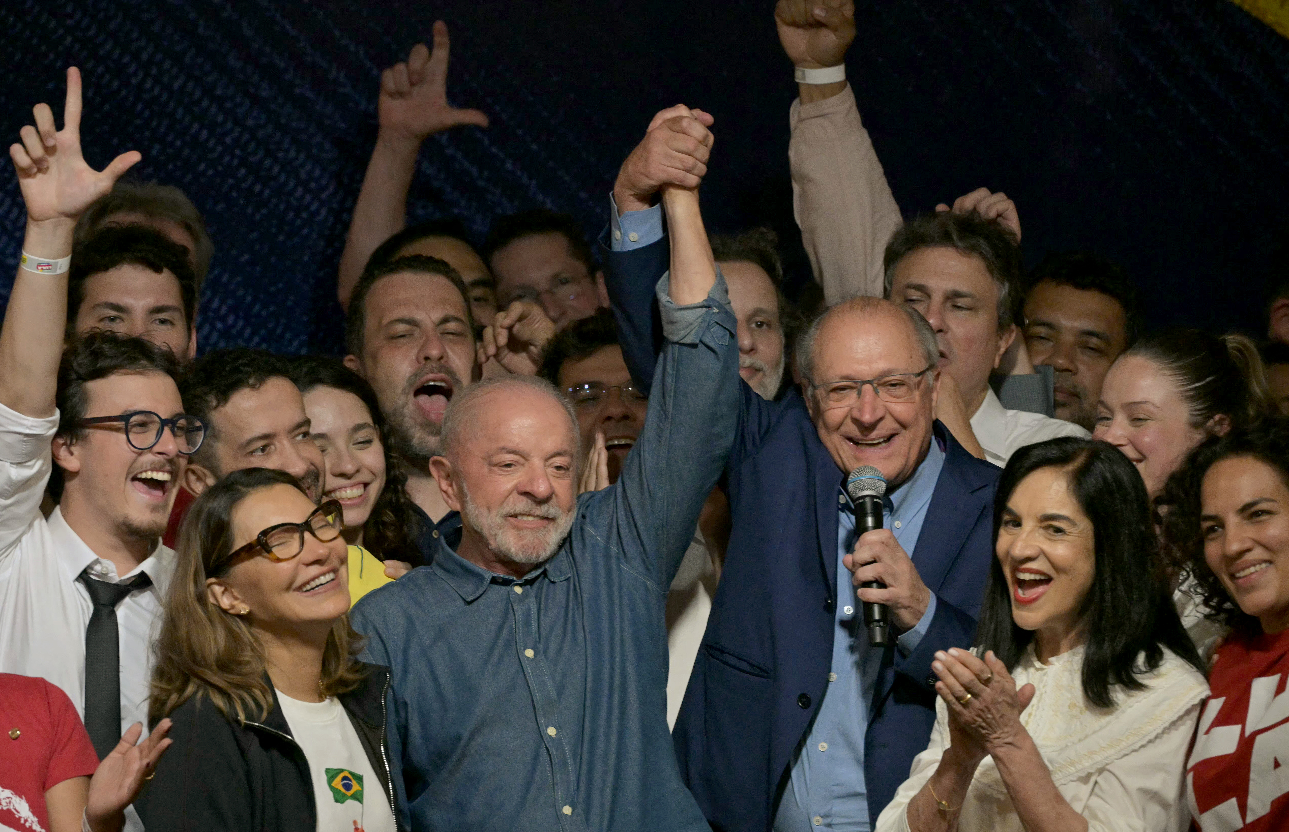 El presidente de Brasil y candidato a la reelección por el Partido de los Trabajadores (PT), Luiz Inácio Lula da Silva, reacciona junto a su esposa, la primera dama Rosangela da Silva (segunda desde la izquierda), y el vicepresidente Geraldo Alckmin (tercero desde la derecha), tras conocer los primeros resultados de la segunda vuelta de las elecciones presidenciales, en São Paulo, Brasil, este 25 de octubre de 2026.