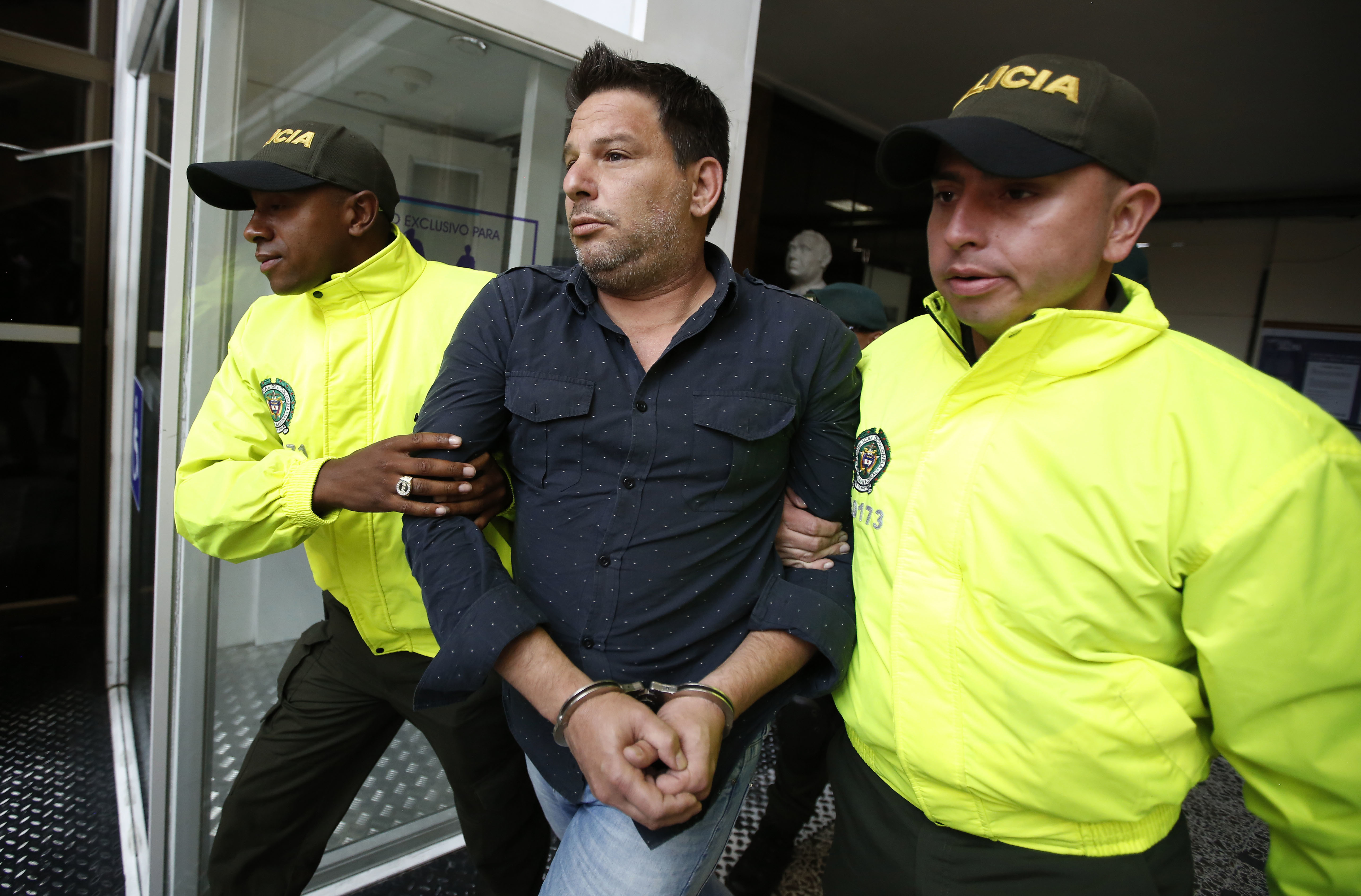 Police escort Cuban suspect Raul Gutierrez to court where a judge will rule on prosecutors’ request he be held on terrorism and conspiracy charges in Bogota, Colombia, Thursday, March 15, 2018. Gutierrez is suspected of plotting to kill American diplomats in the name of the Islamic State. (AP Photo/Fernando Vergara)