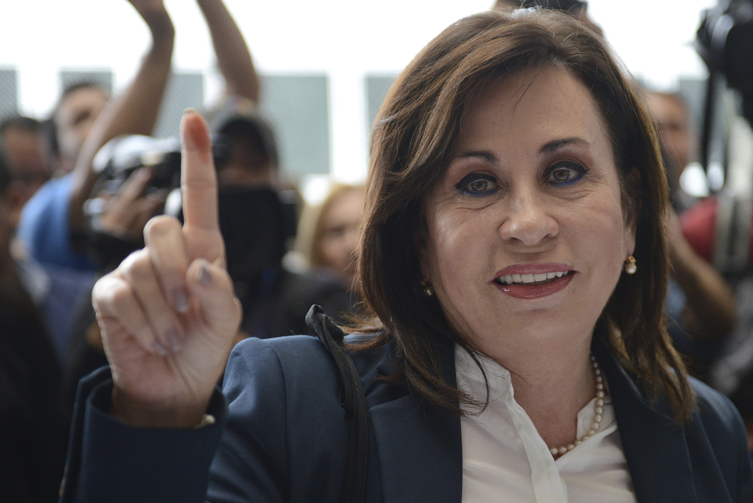 FILE - In this Oct. 25, 2015 file photo, former first lady Sandra Torres, who's running for president with the National Unity of Hope party, shows her inked finger after voting during the presidential runoff election in Guatemala City. Guatemala’s attorney general’s office asked on Wednesday, Feb. 6, 2019, that the immunity of Torrez, who is now an official presidential candidate and is therefore immune from prosecution, be lifted as she now stands accused of several electoral crimes during her 2015 presidential run. (AP Photo/Oliver de Ros, File)