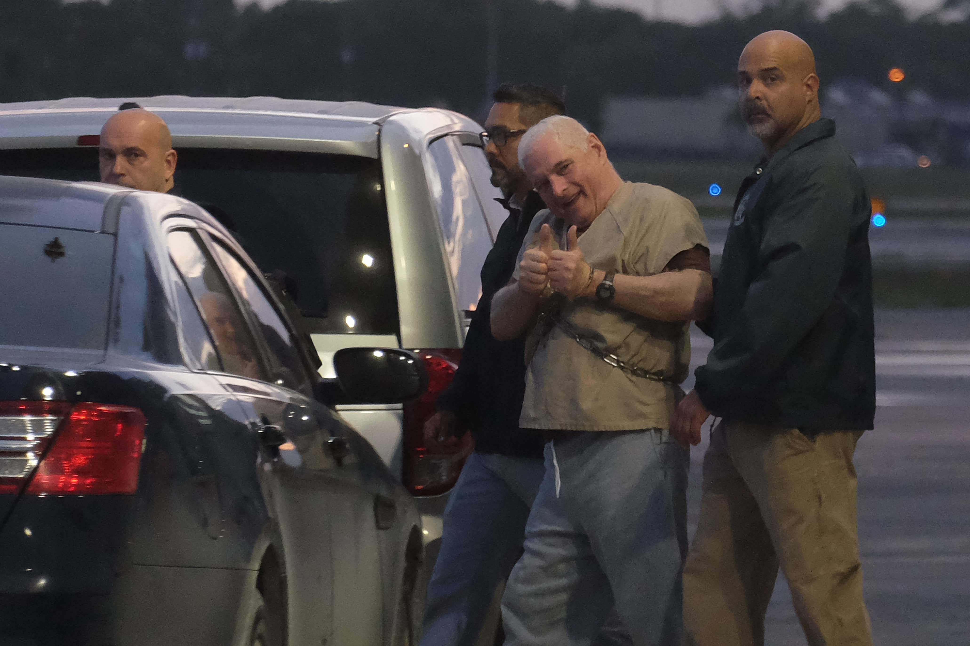 El ex presidente panameño Ricardo Martinelli es escoltado por alguaciles de EE. UU. hacia un avión en la madrugada del 11 de junio de 2018 en el aeropuerto de Opa Locka, cerca de Miami, FL.