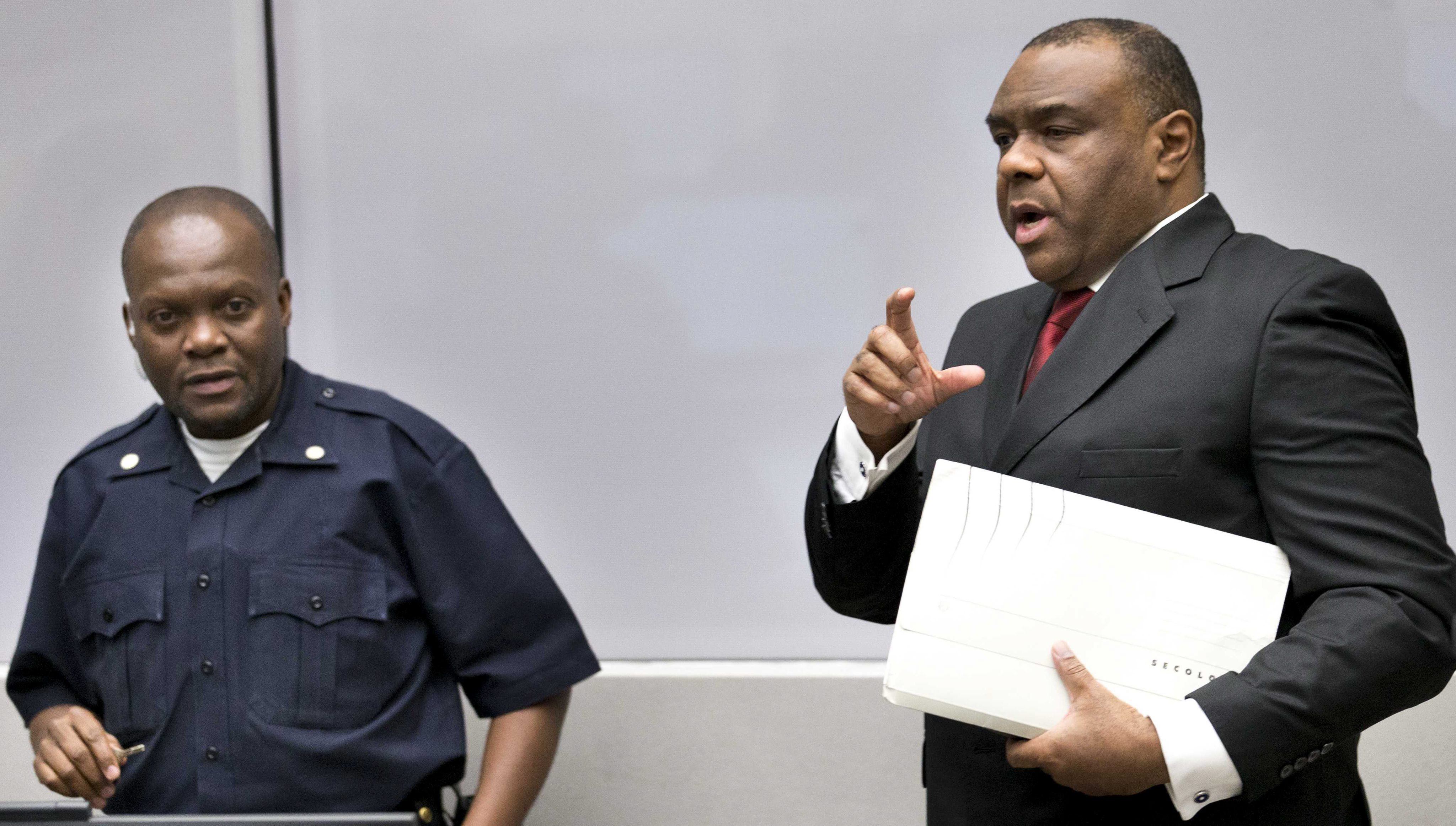 El exlíder rebelde congoleño Jean-Pierre Bemba (der.), condenado por crímenes de guerra y de lesa humanidad a su llegada a la Corte Penal Internacional (CPI) en La Haya, Holanda este lunes 21 de marzo.