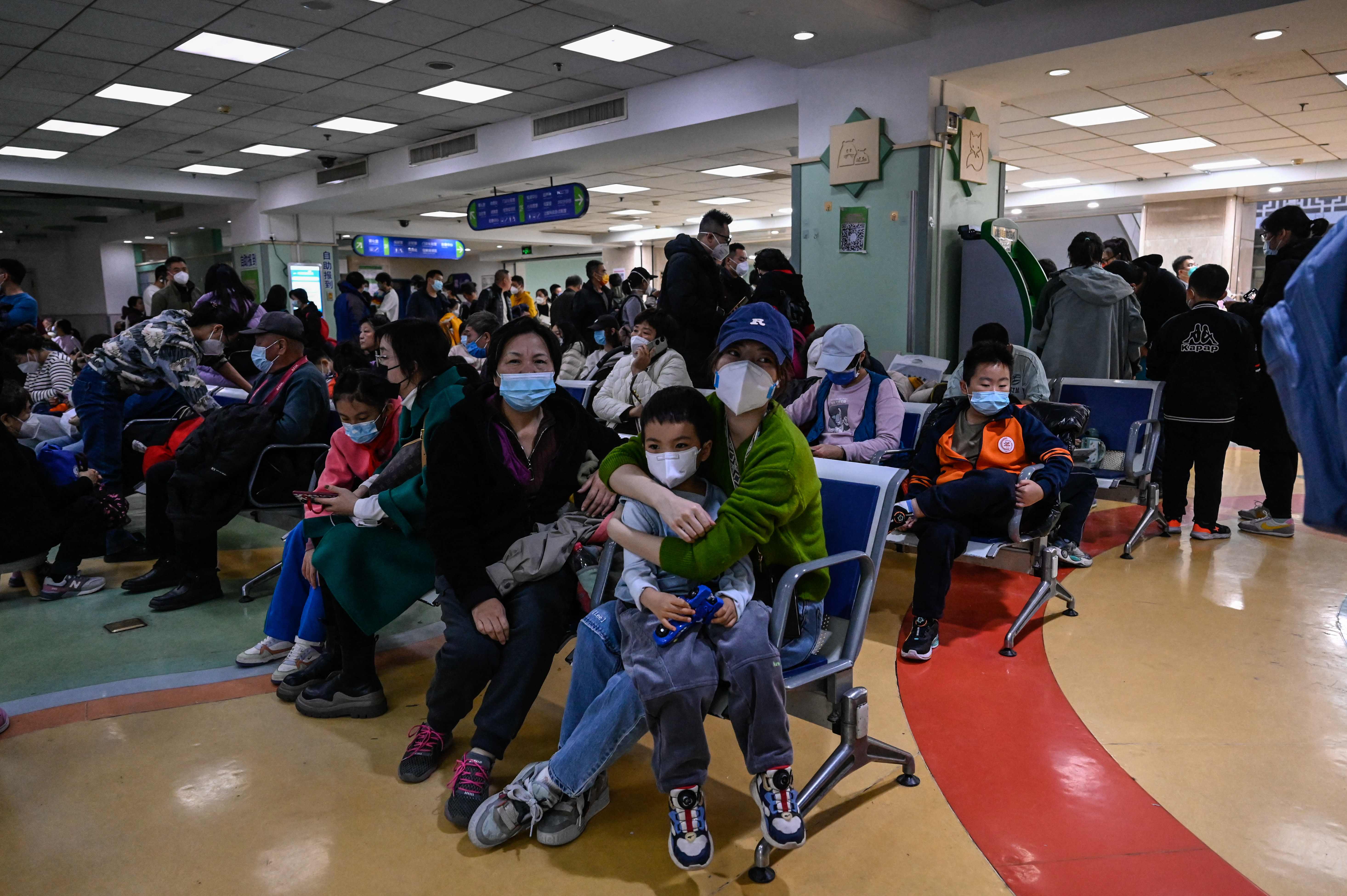 TOPSHOT - Children and their parents wait at an outpatient area at a children hospital in Beijing on November 23, 2023. The World Health Organization has asked on November 23, 2023, China for more data on a respiratory illness spreading in the north of the country, urging people to take steps to reduce the risk of infection. China has reported an increase in "influenza-like illness" since mid-October when compared to the same period in the previous three years, the WHO said. (Photo by Jade Gao / AFP)