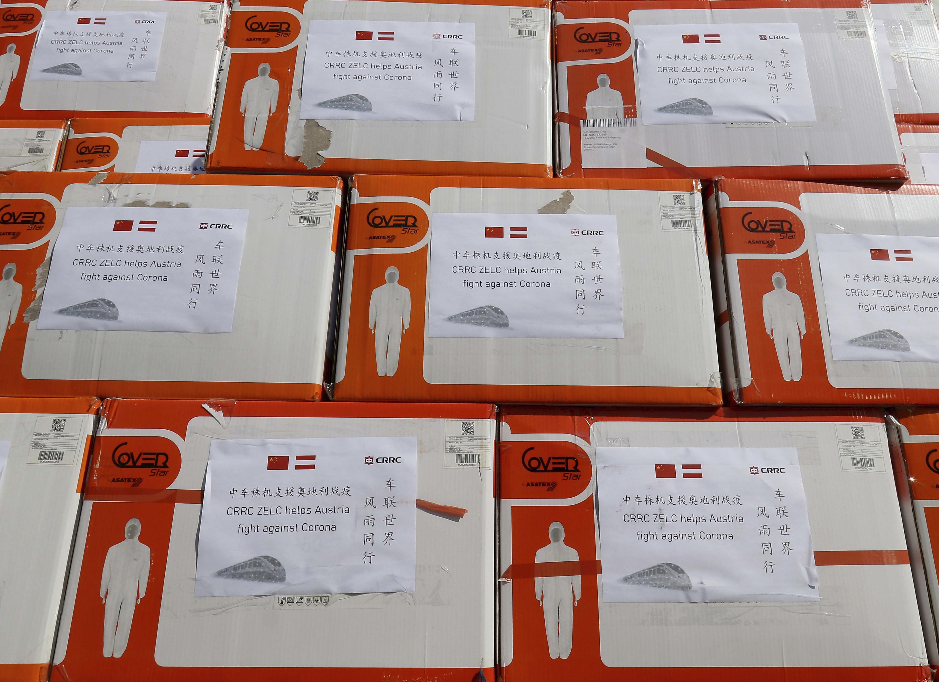 Protective suits and masks are in boxes in Vienna, Austria, Friday, March 20, 2020. China Railway Rolling Stock Corporation, CRRC, donates 3.000 protective suits and 150.000 masks to the emergency organizations in Austria. For most people, the new coronavirus causes only mild or moderate symptoms, such as fever and cough. For some, especially older adults and people with existing health problems, it can cause more severe illness, including pneumonia. (AP Photo/Ronald Zak)